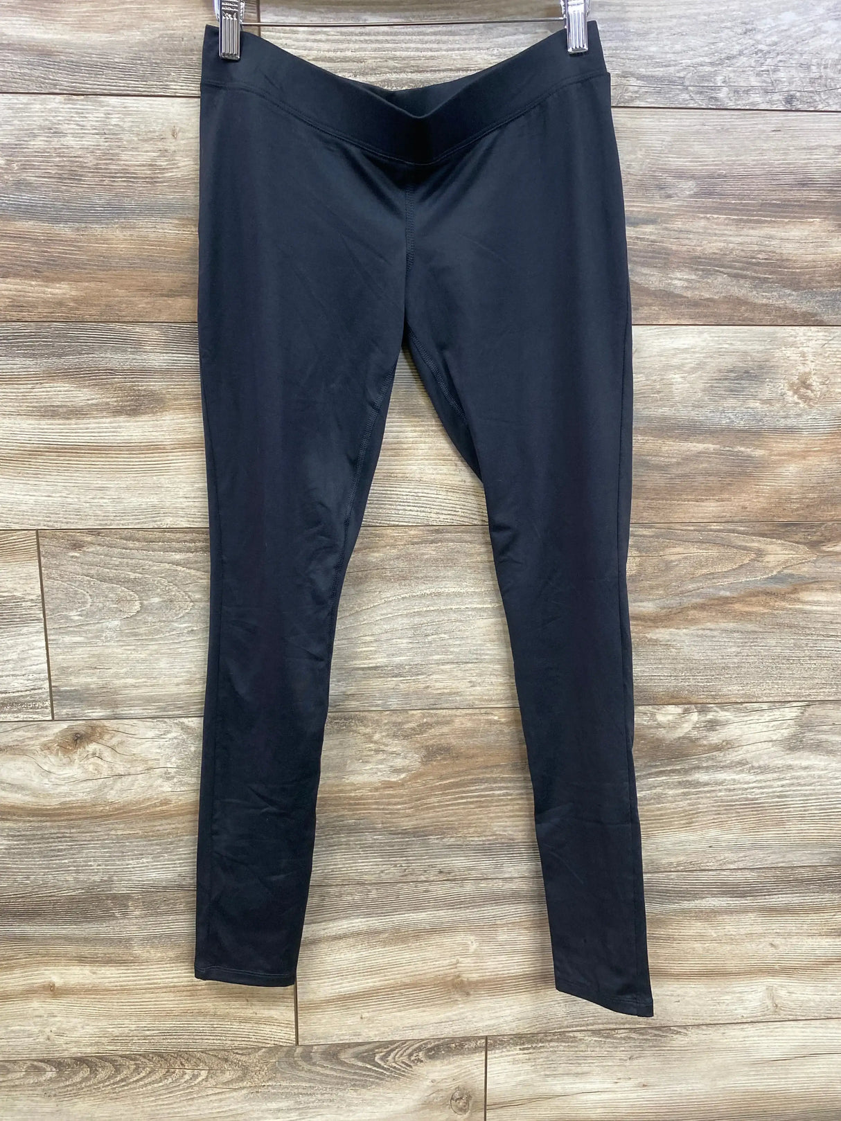 Front view of Isabel maternity leggings in black, size XS, showing under-belly V waistband and slim legs on wood background