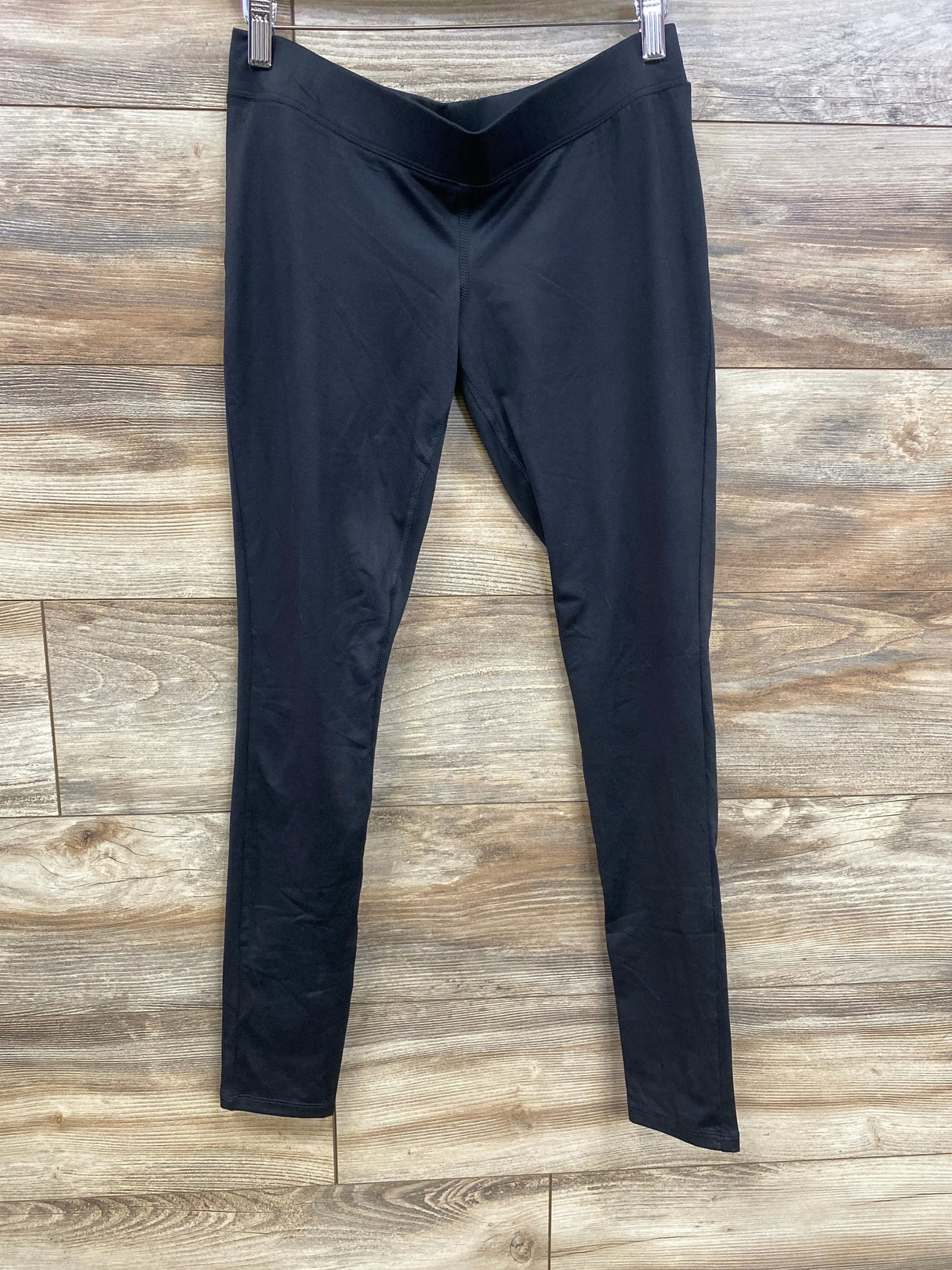 Front view of Isabel maternity leggings in black, size XS, showing under-belly V waistband and slim legs on wood background