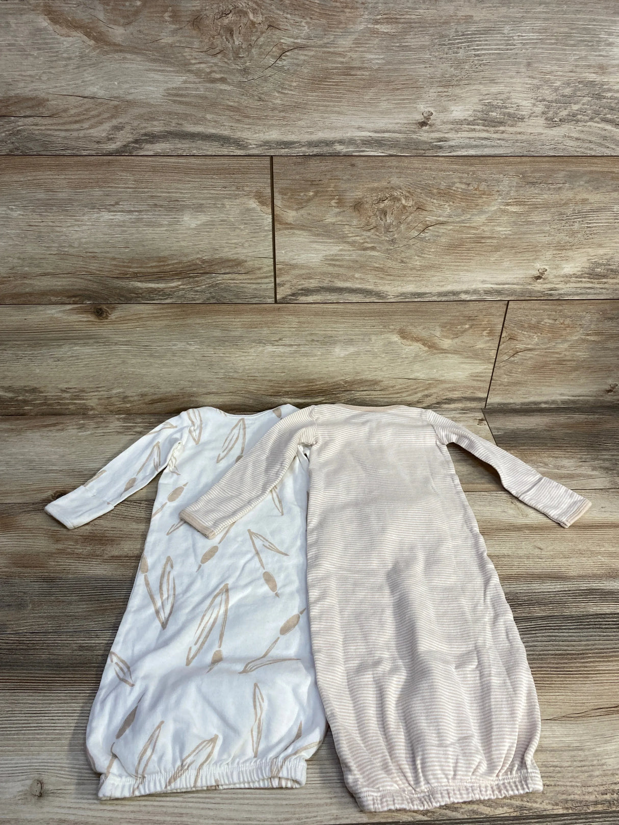 Top-down of Carter's 2-piece baby sleeper gowns: tan stripe and white with tan leaf print, long sleeves, elastic bottoms