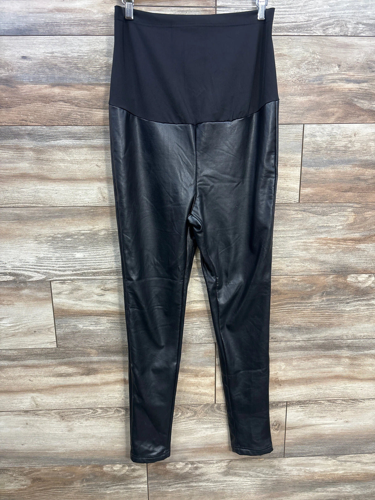 Black faux leather high waisted leggings on wood background