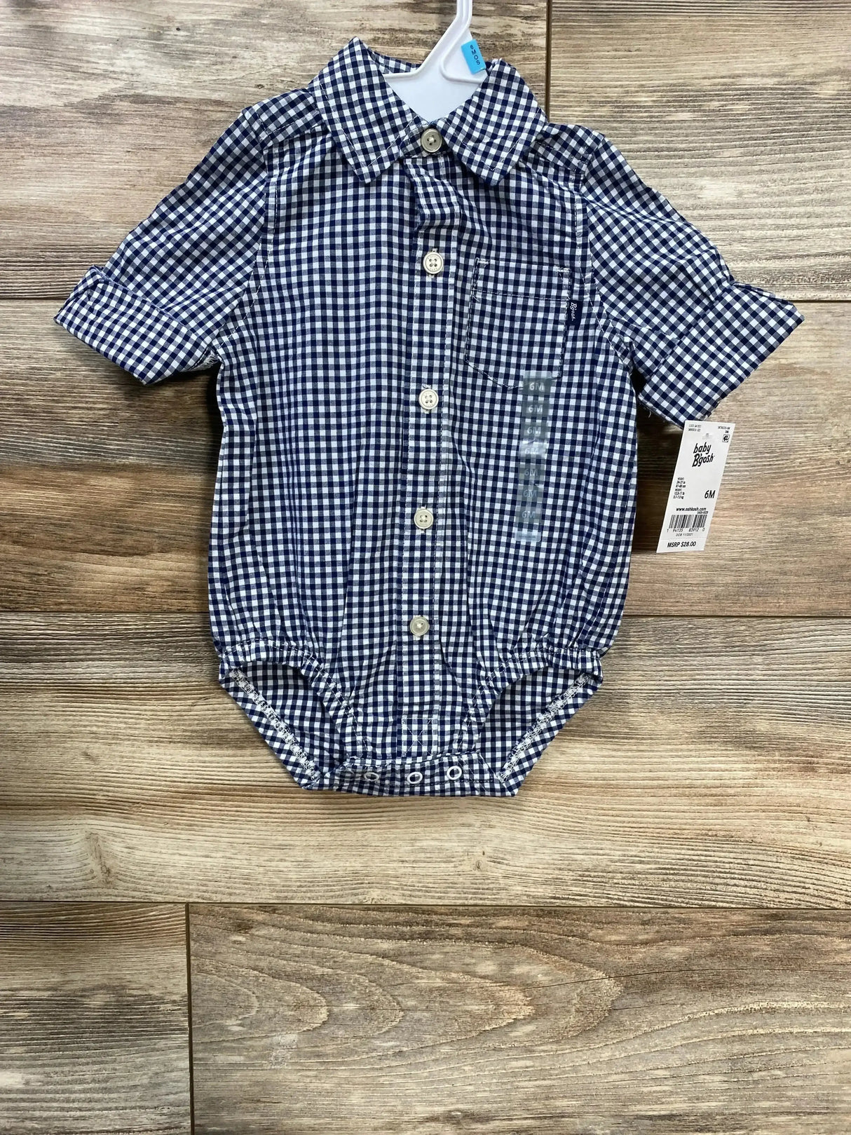 Front view of navy gingham baby bodysuit with button-front, chest pocket, short sleeves, and crotch snaps on wood background