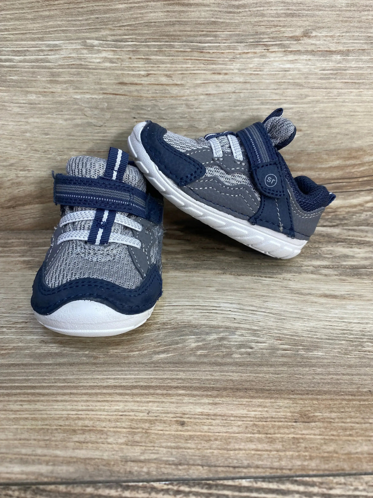 Side view of navy Stride Rite Soft Motion Kylo toddler sneaker showcasing hook-and-loop strap and cushioned sole on white background