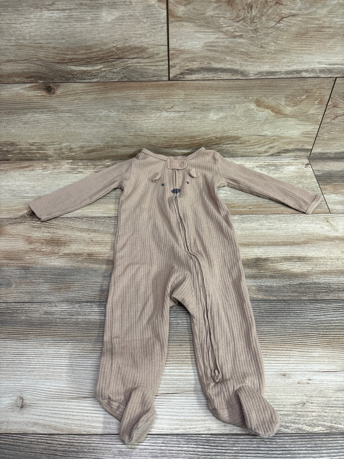 Brown Carter's ribbed baby sleeper with bear ears on a wooden background