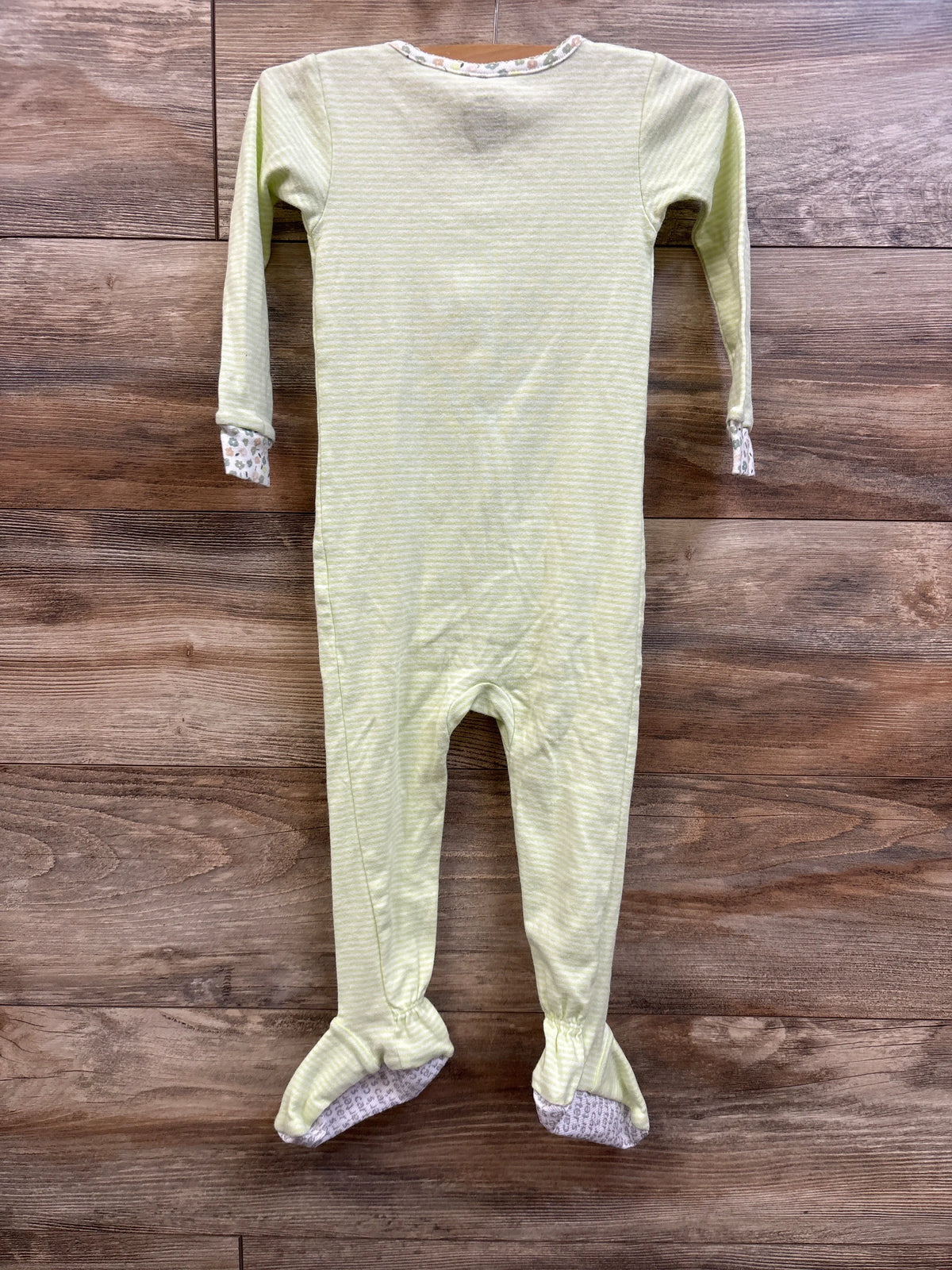 Front view of Carter’s lime green striped sleeper, size 24 months, with long sleeves and footed legs on a wood background