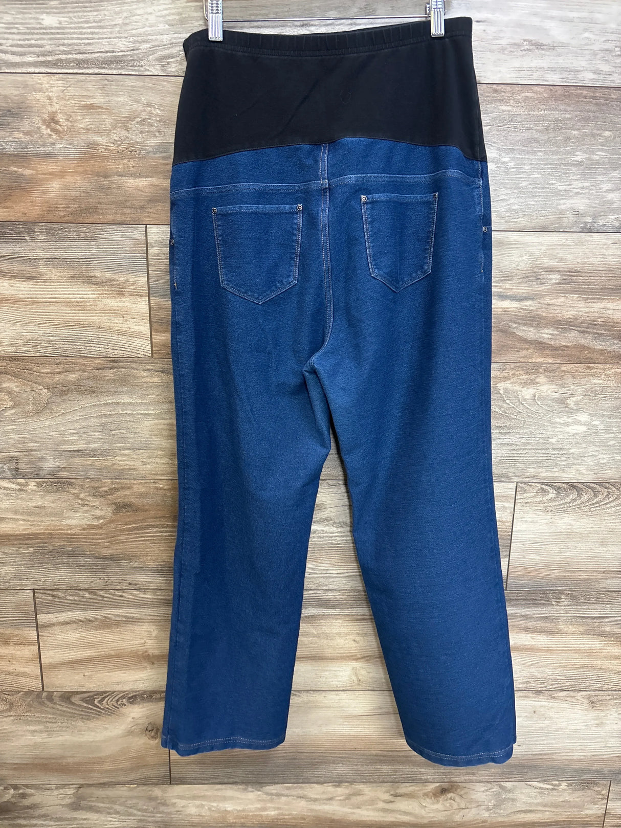 Back view of Time and Tru maternity jeans showing black panel waistband, blue denim, patch back pockets on wood floor
