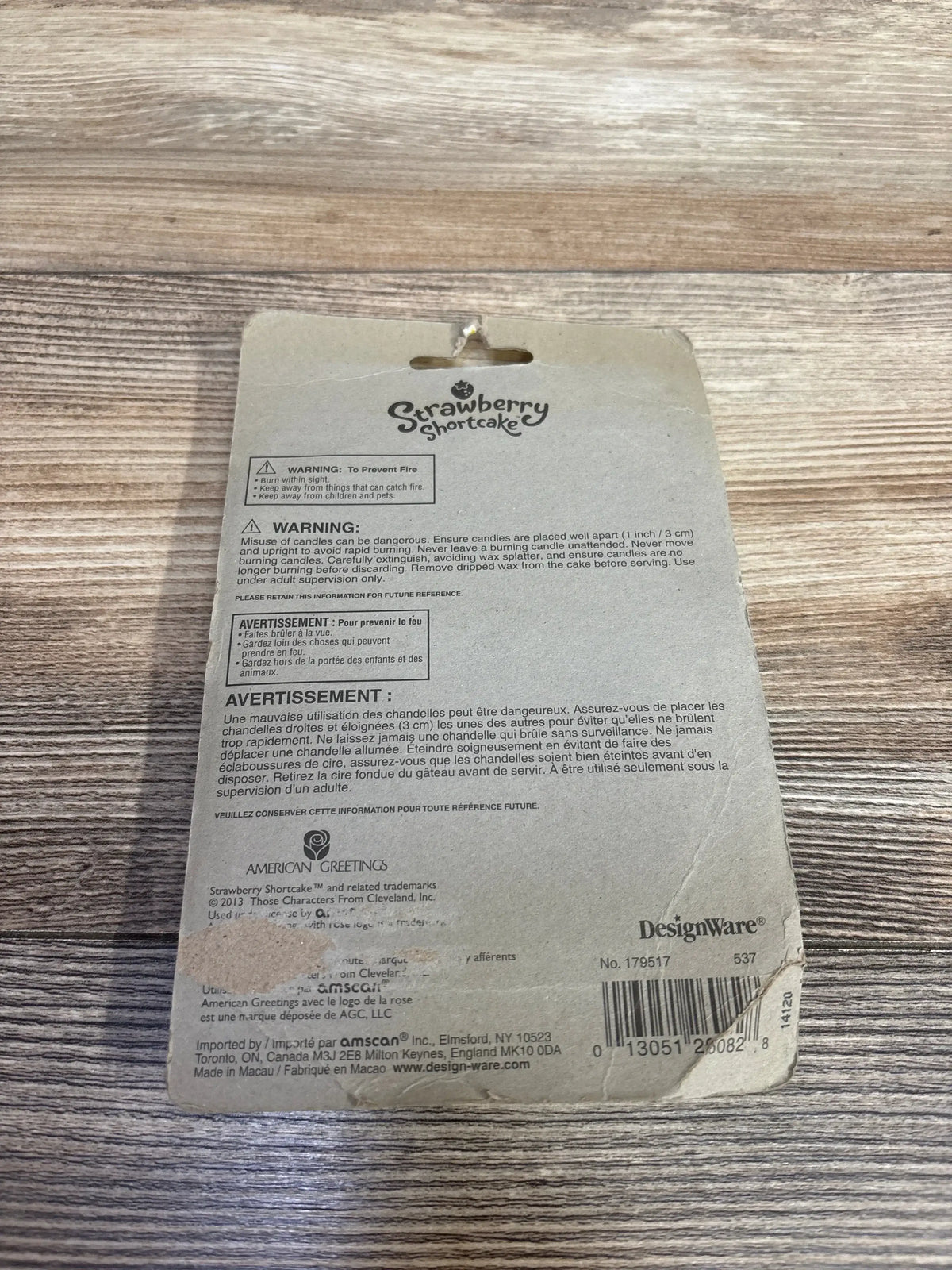 Strawberry Shortcake vintage packaging with safety warnings on a wooden surface