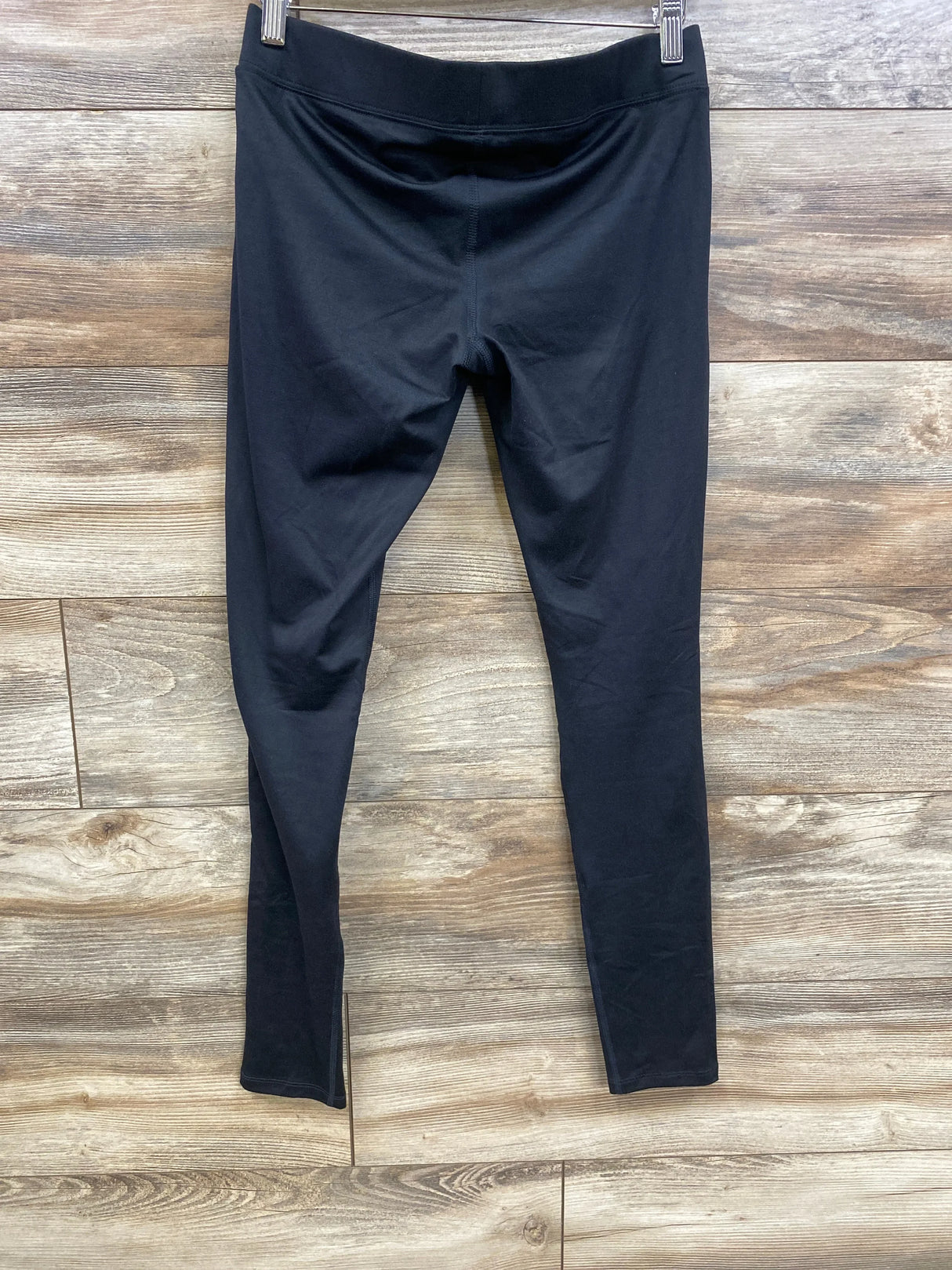 Front view of black Isabel maternity under-belly leggings showing low waistband and full-length legs on wood background