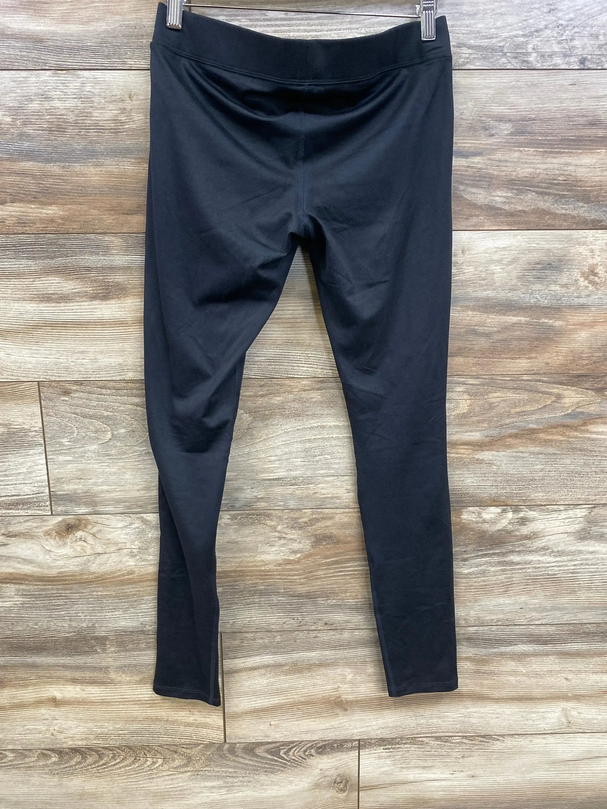 Front view of black Isabel maternity under-belly leggings showing low waistband and full-length legs on wood background