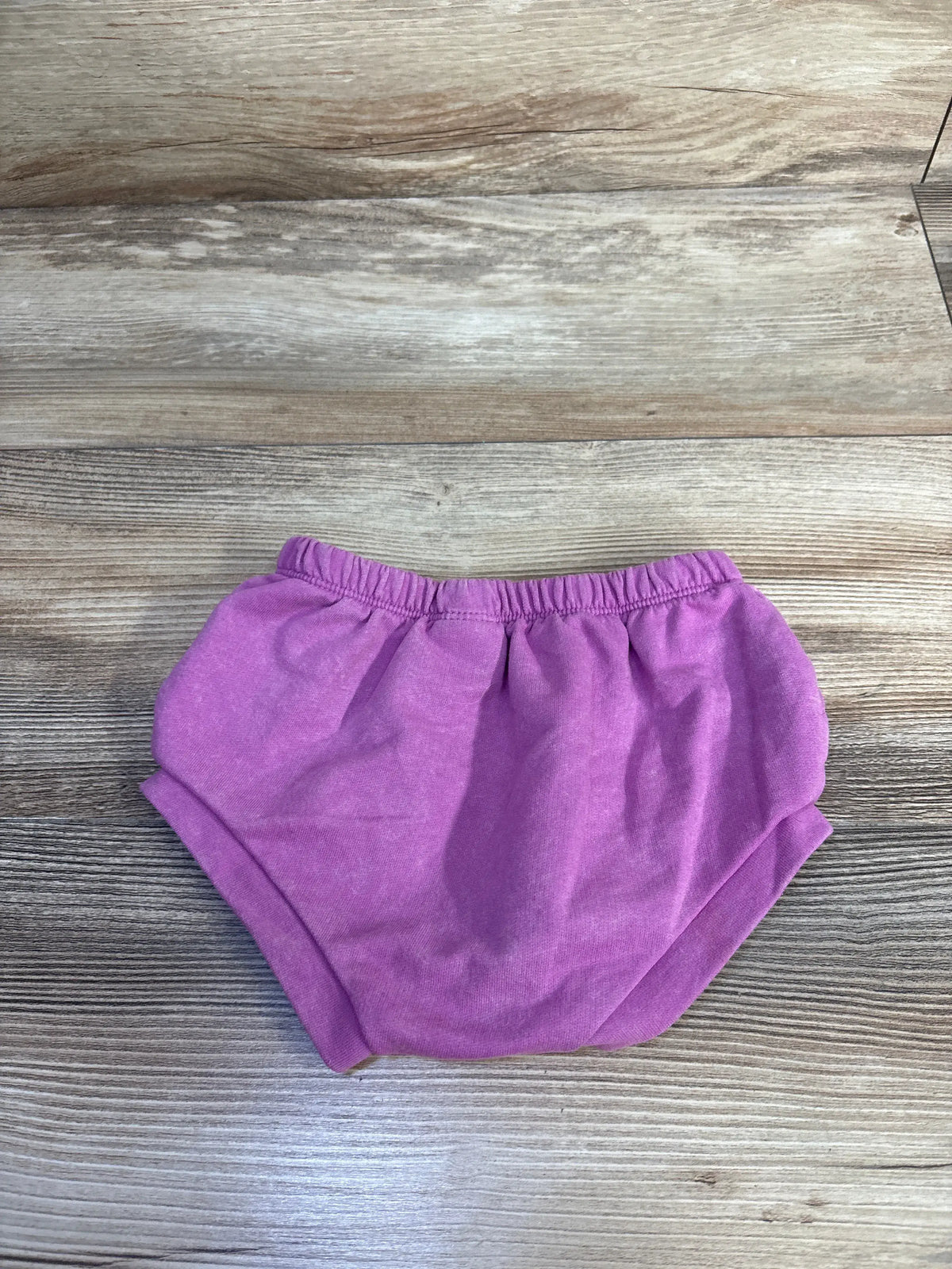 Front view of Cat & Jack bloomers showcasing elastic waistband and leg openings with a wood-grain background