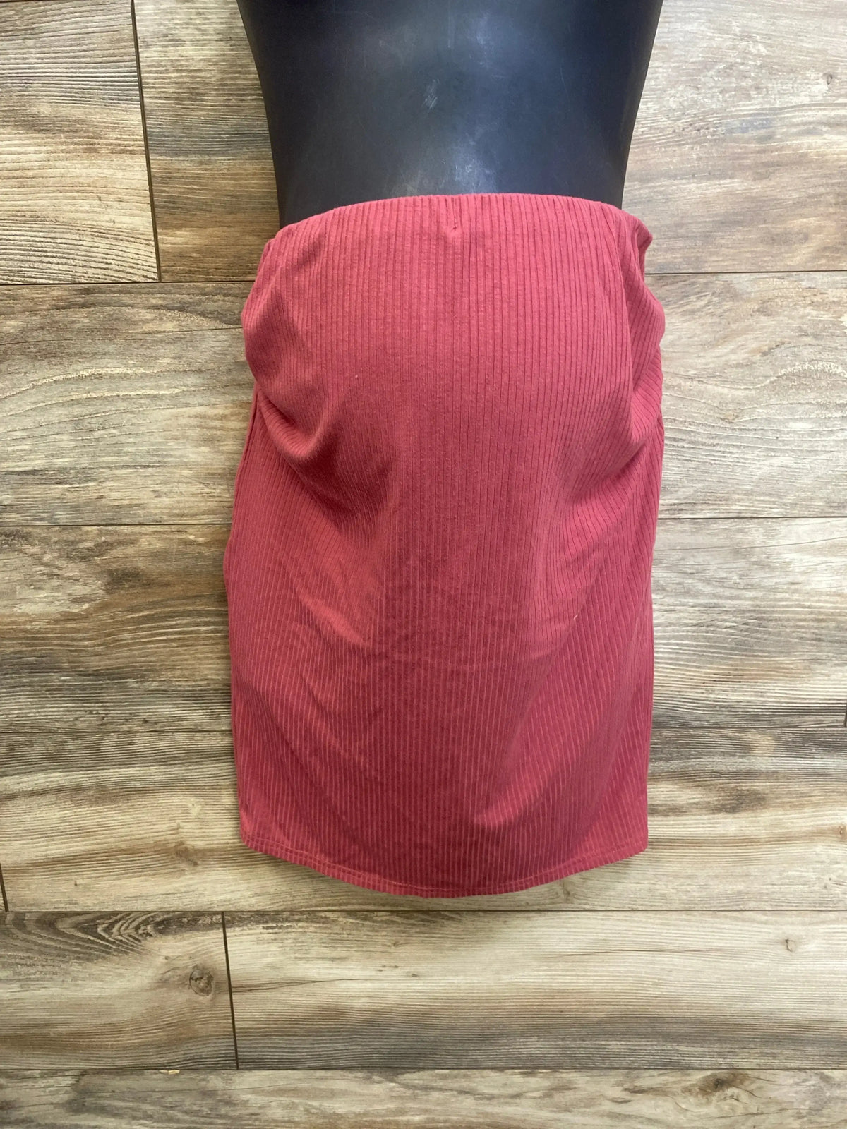 Front view of Shein maternity ribbed skirt in red, size Medium, showcasing ribbed fabric on wood flooring