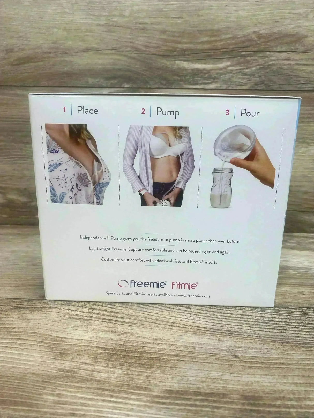 Rear view of Freemie Independence II breast pump box showing three-step ‘Place, Pump, Pour’ instruction images on wooden tabletop