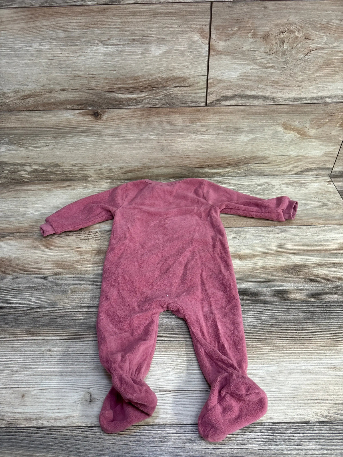 Back flat lay of hot pink fleece footed baby sleeper, long sleeves, size 3-6M on wooden floor