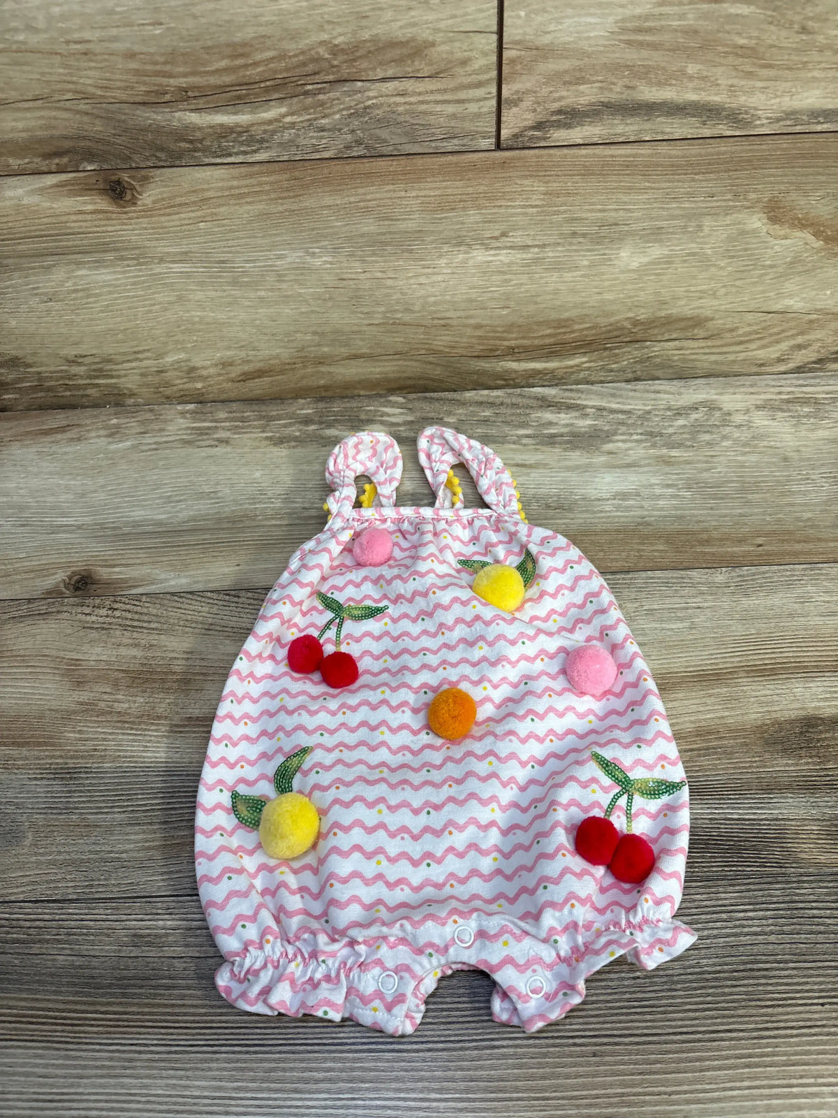Front view of Mudpie Chevron Pom Pom Fruit Shortie Romper showcasing pink and white chevron fabric with fruit pom poms
