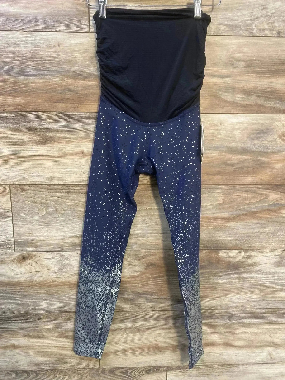 Front view of Beyond The Bump maternity full-panel leggings, navy blue with white speckled ombre, hanging on wood background