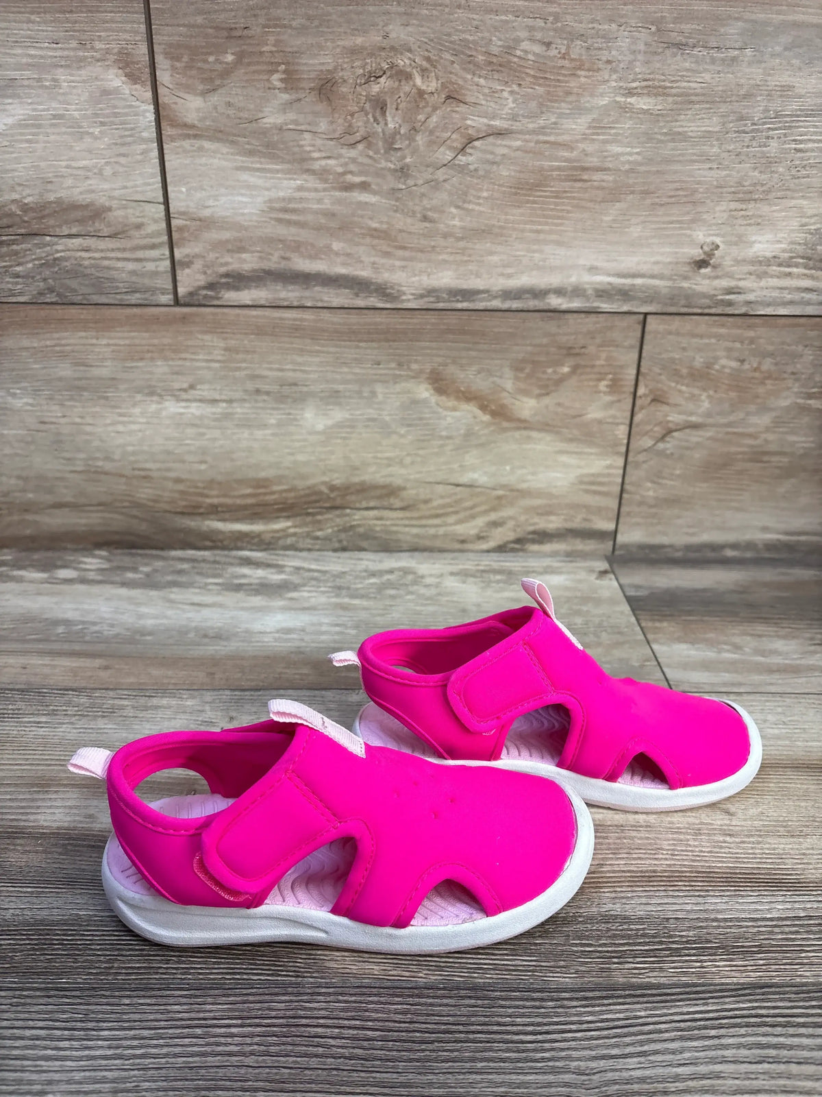 Side view of pink Cat & Jack Speedo water shoes showcasing hook-and-loop closures with a wood-look background