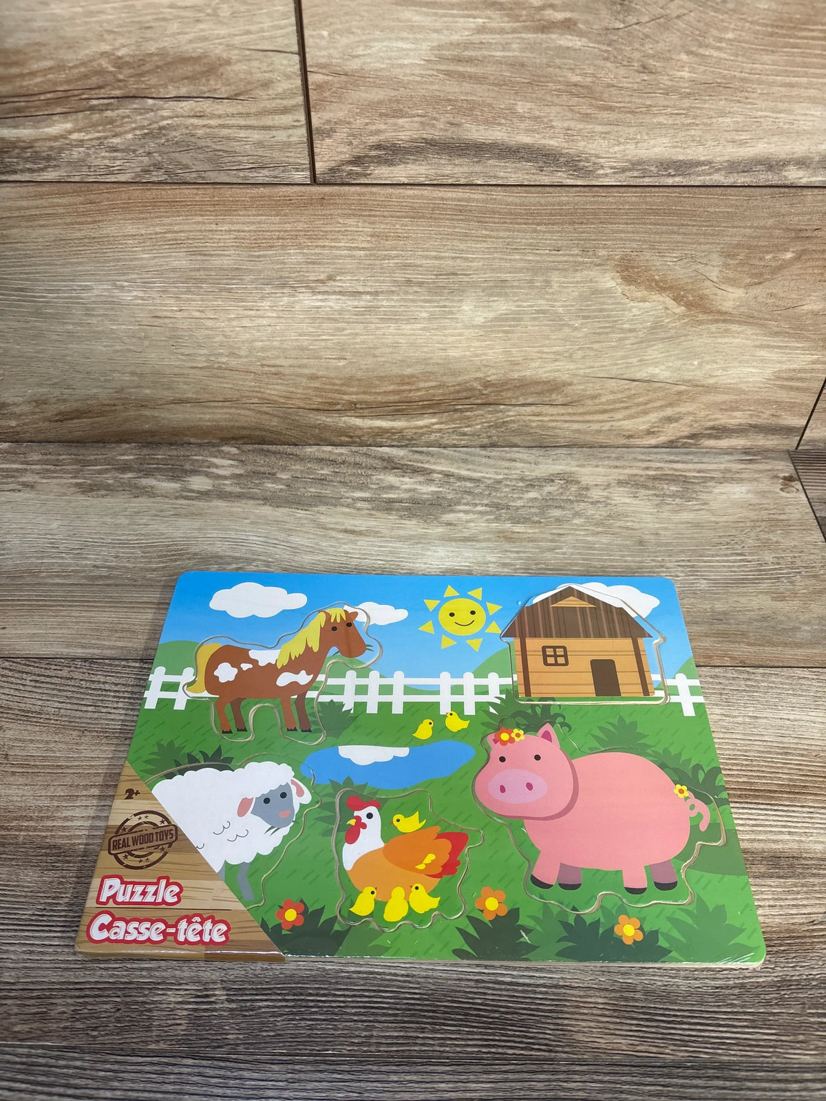 Top down of Greenbrier wood farm puzzle with five chunky animal pieces, horse, pig, sheep, hen with chicks