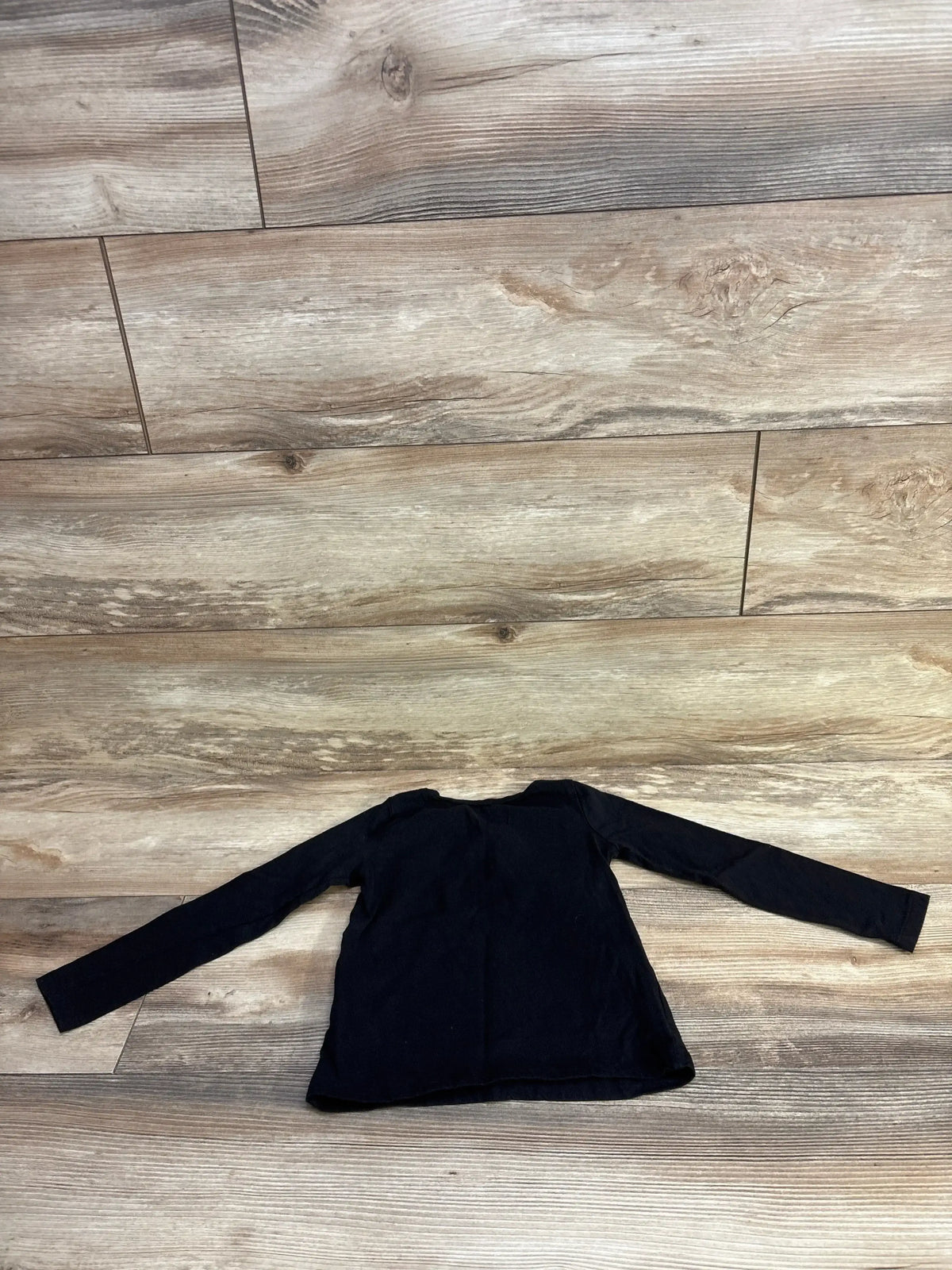 Front view of Children’s Place 100% cotton black long sleeve shirt, size 3T, laid flat on wood flooring