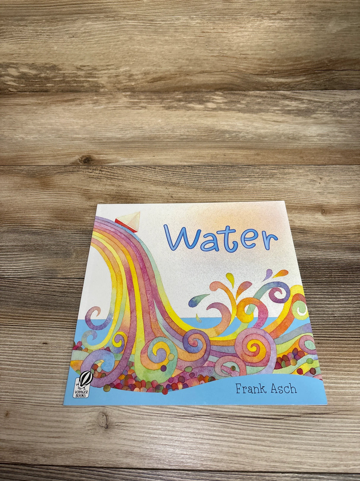 Children's book Water by Frank Asch with colorful swirling water art on wooden surface