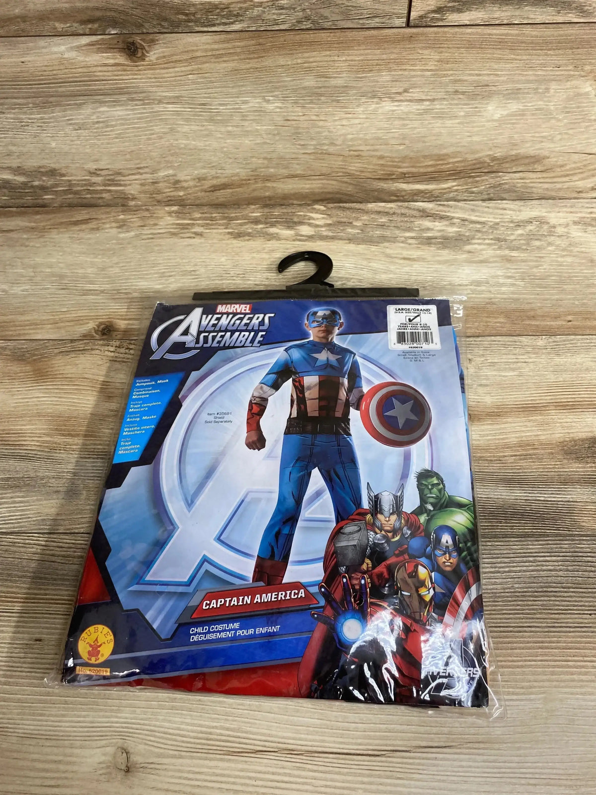 Front view of Rubie’s Captain America child costume package showcasing Captain America suit and shield with Avengers artwork on a wood surface