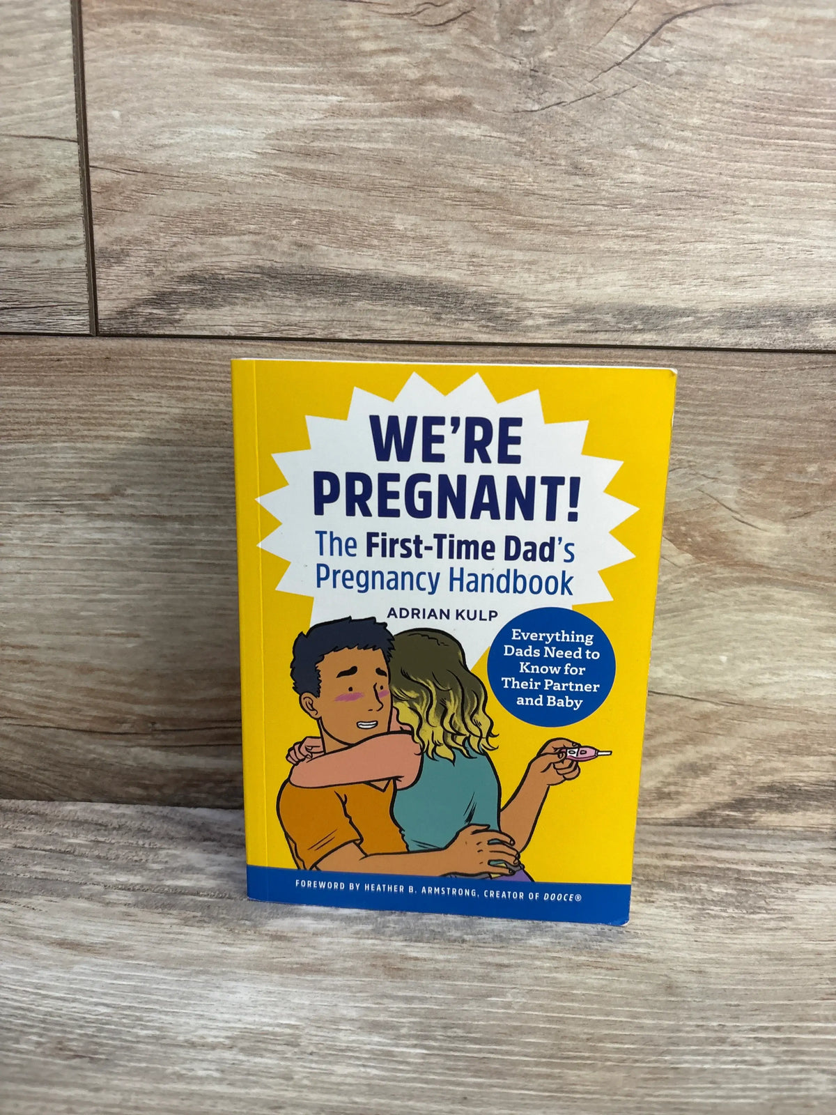 Front view of We’re Pregnant! The First-Time Dad’s Pregnancy Handbook paperback book showing couple and pregnancy test