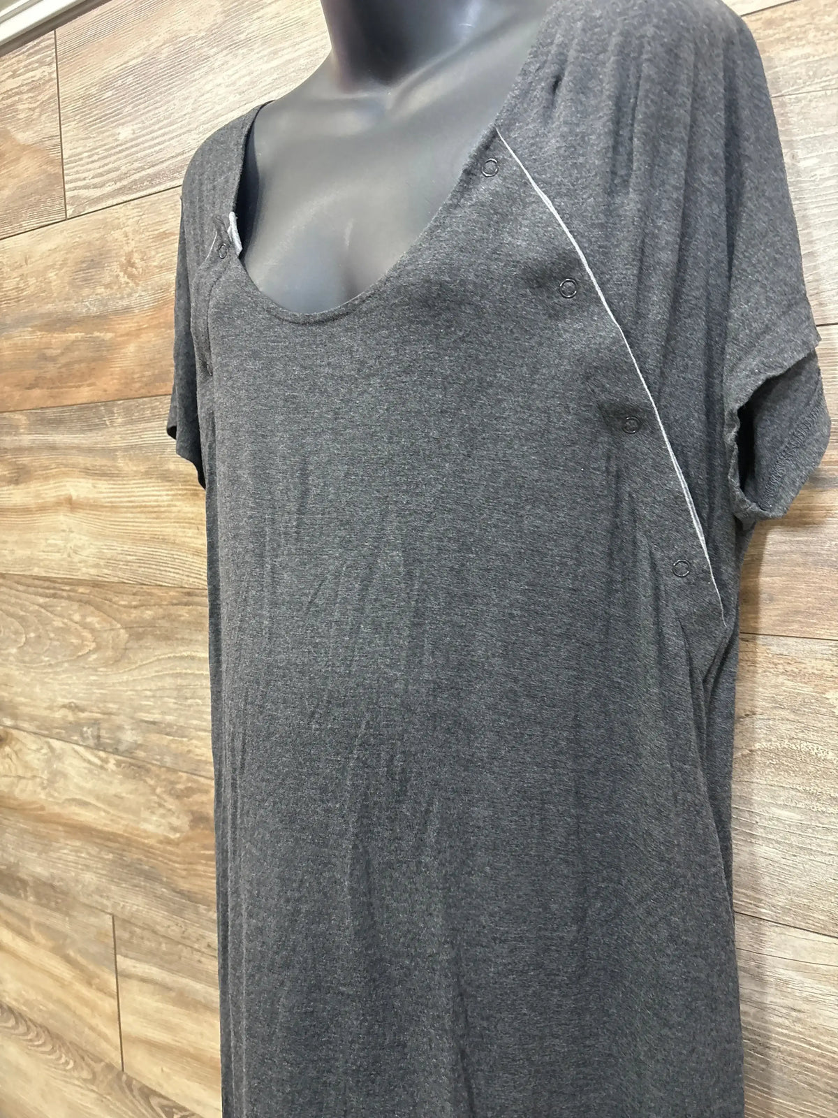 Front of Frida delivery and nursing gown with scoop neck, side snap openings, short sleeves, charcoal grey on wood background