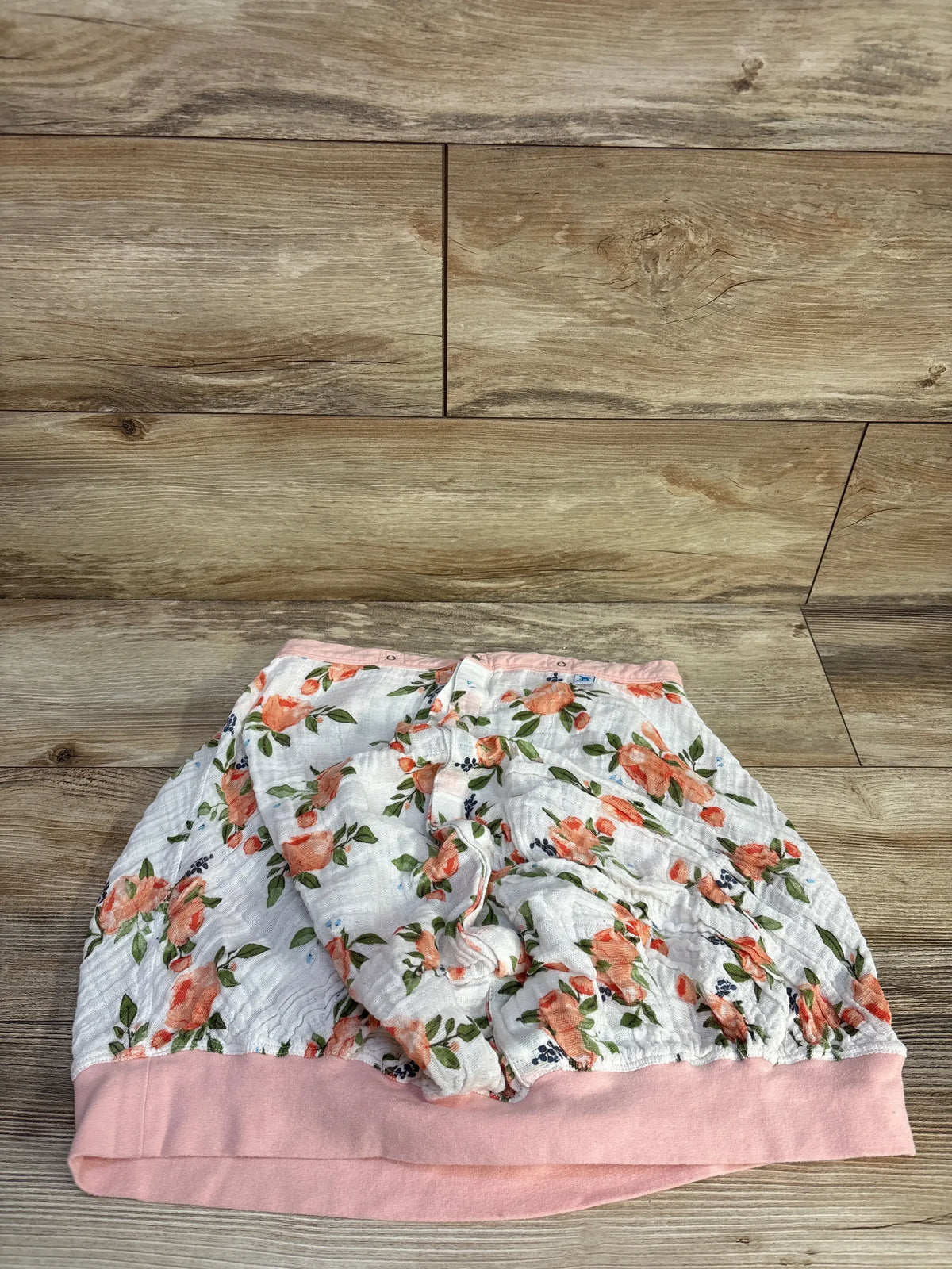 Little Unicorn cotton muslin car seat cover with pink watercolor roses on a wood background