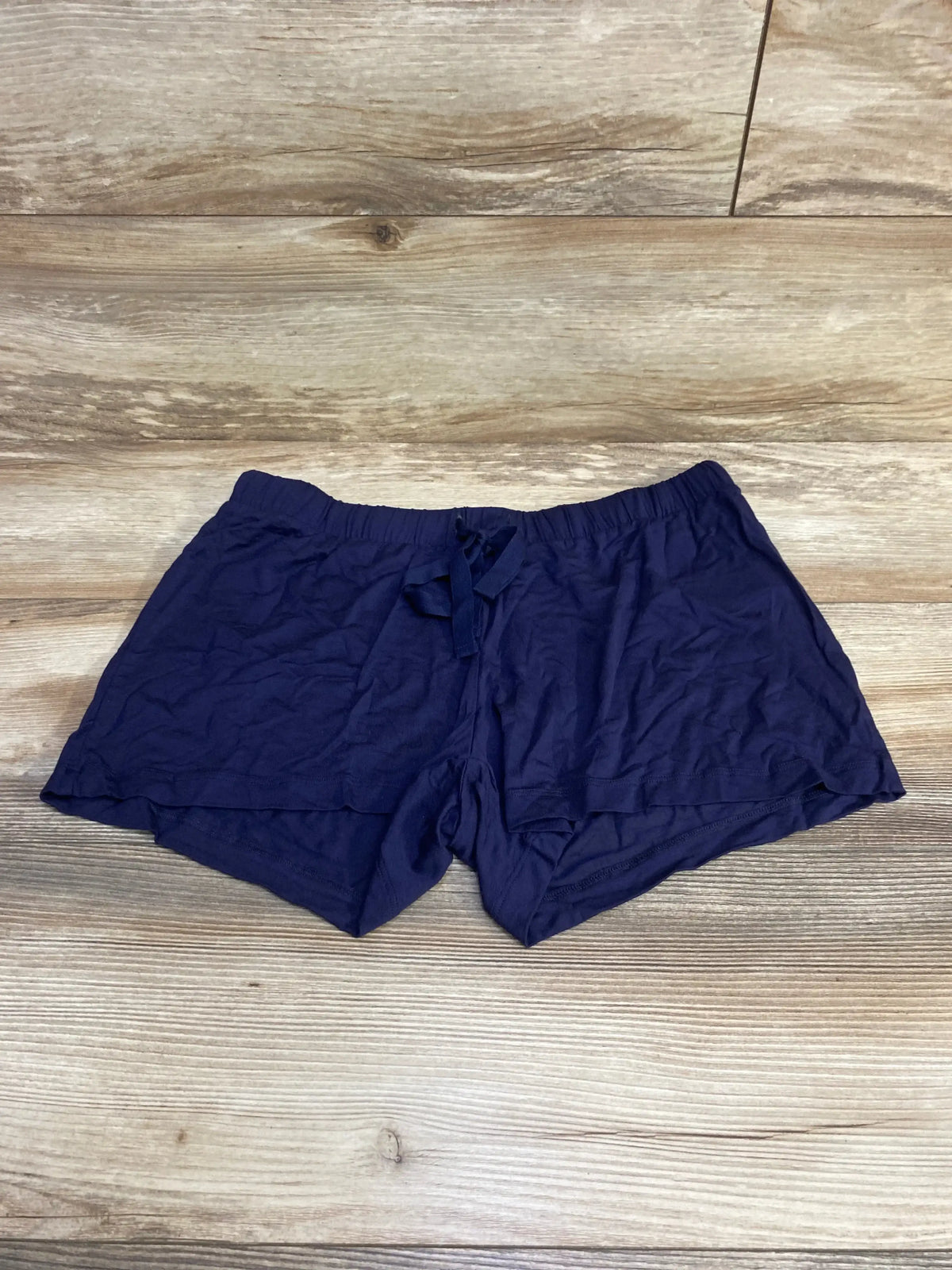 Flat lay of navy Gap Body maternity modal shorts showing elastic drawstring waistband and lightweight soft fabric on wooden floor