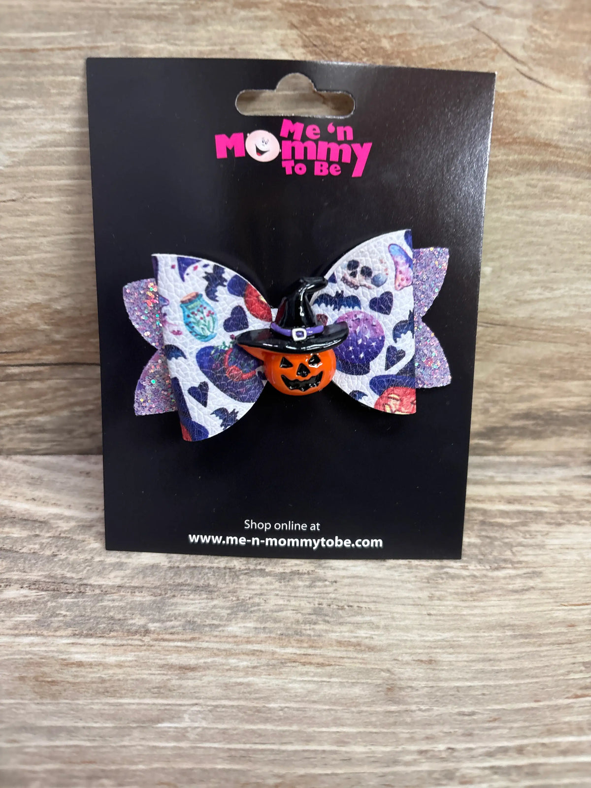 White Halloween hair bow with purple patterns, a pumpkin applique wearing a witch hat.