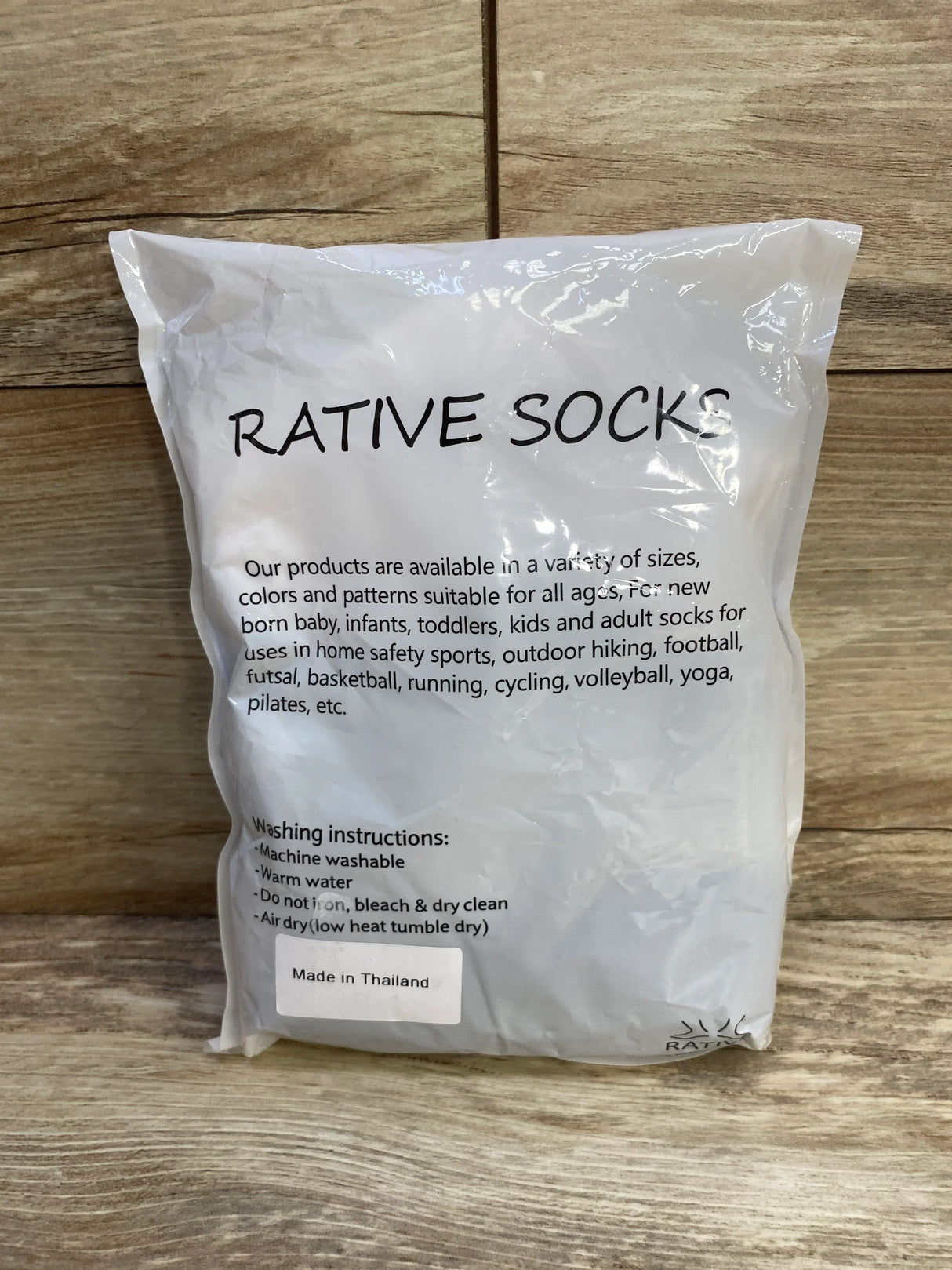 Front view of New Rative non-slip baby crew socks 12-pack in bag showing 'RATIVE SOCKS' and 'Made in Thailand' on wood