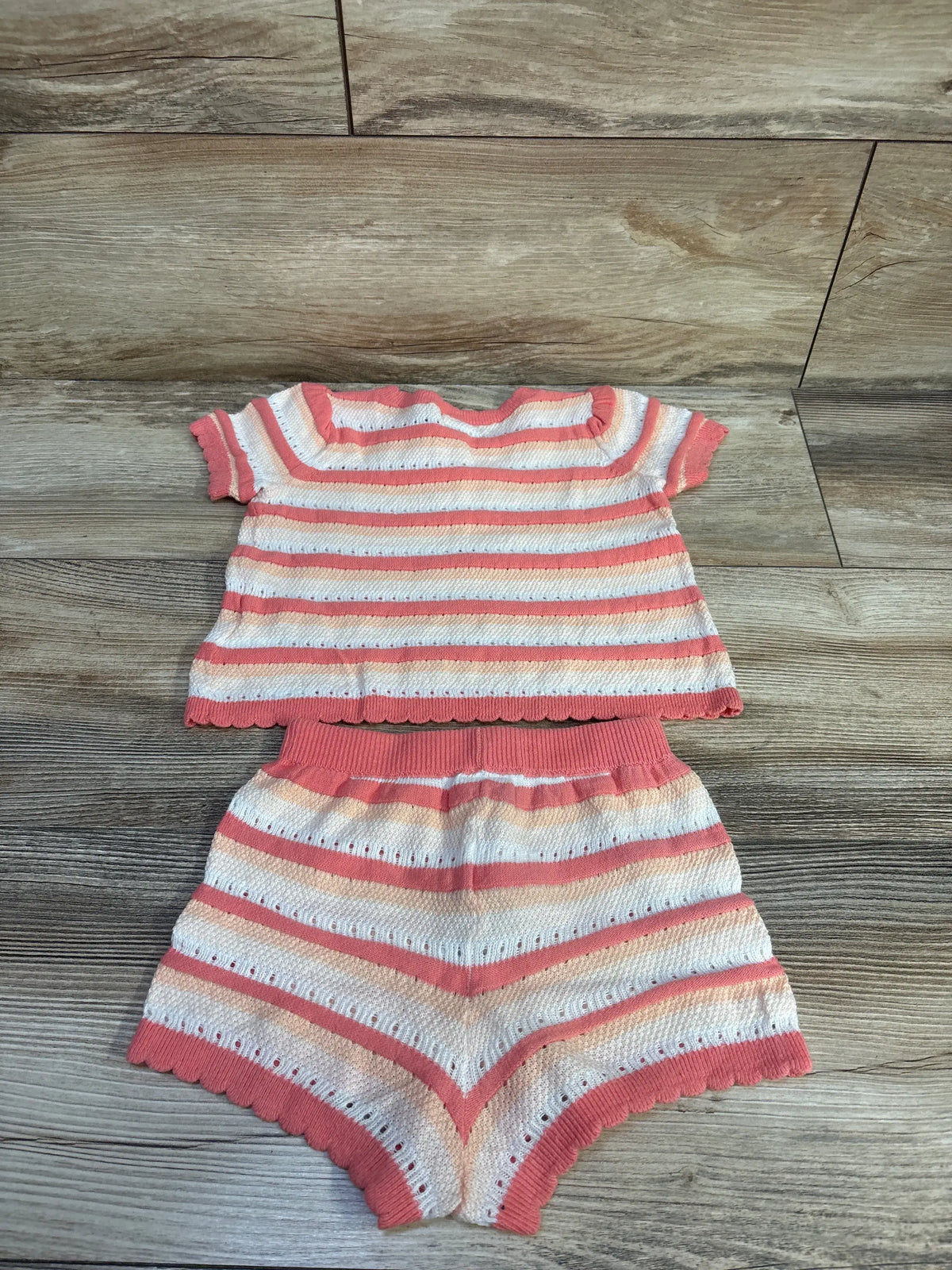 Front view of Baby Gap 2pc striped crochet shirt and shorts set showcasing pink stripes and crochet texture on wood floor