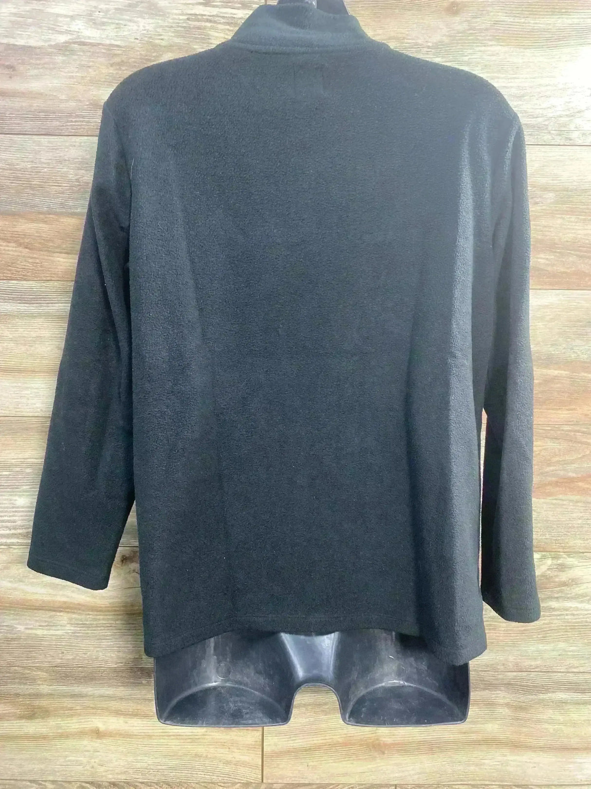 Back view of black maternity nursing sweatshirt with mock neck, long sleeves and soft fleece texture on wood background
