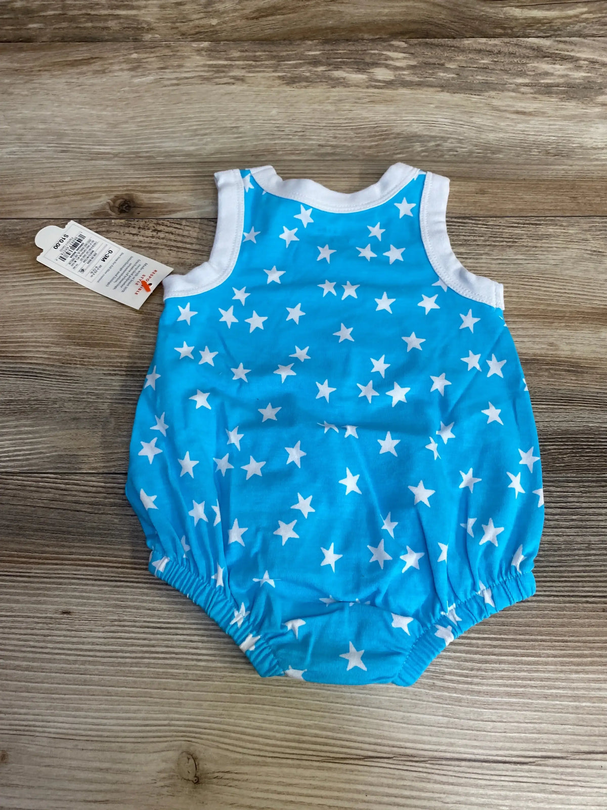 Flat lay back view of newborn blue star print Cat & Jack romper showing sleeveless top and elastic leg openings on wood surface