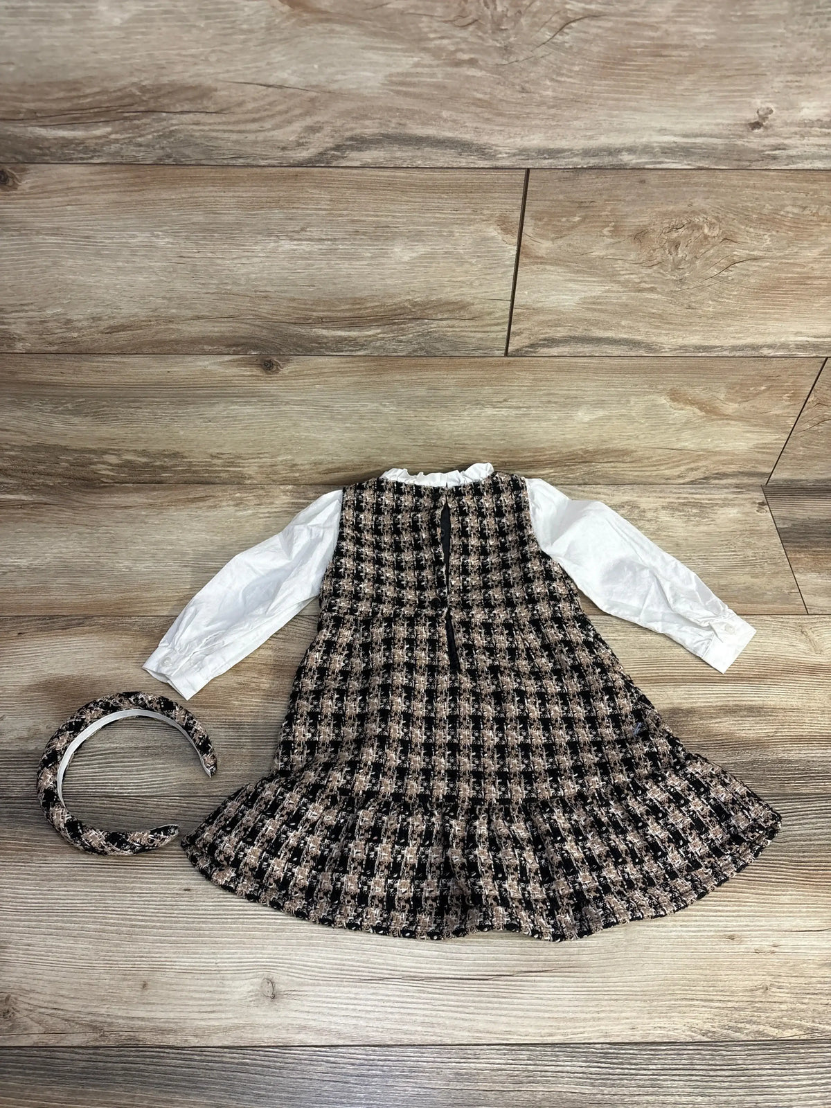 Girls' plaid tweed dress with white long sleeves and matching tweed headband on wooden floor