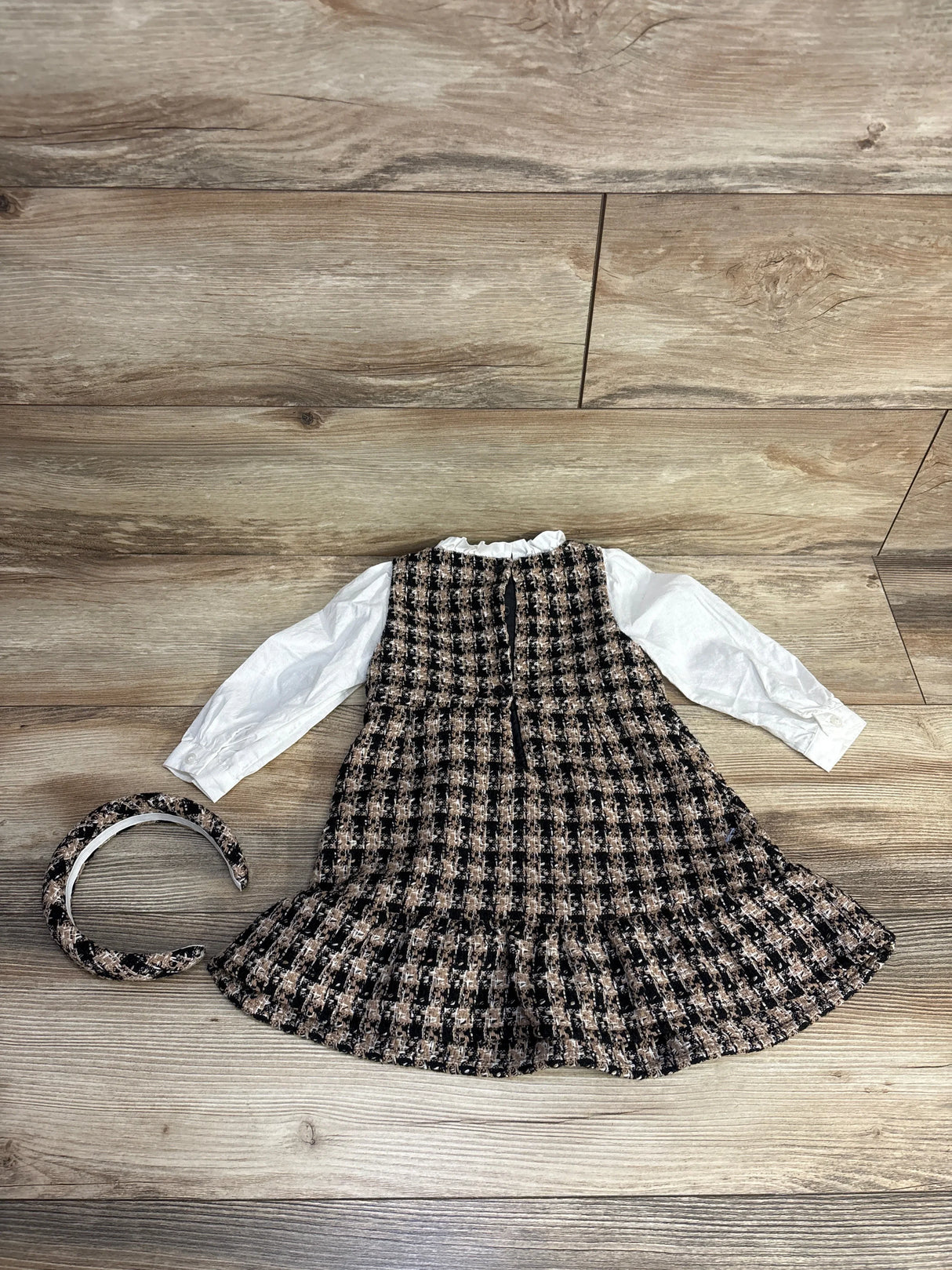 Girls' plaid tweed dress with white long sleeves and matching tweed headband on wooden floor