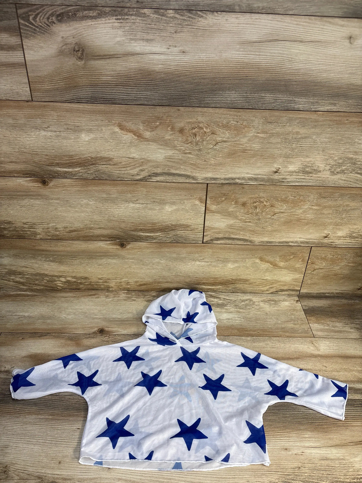 Front view of Shein 4T white mesh hooded swim cover-up with blue star print and long sleeves on a wood floor