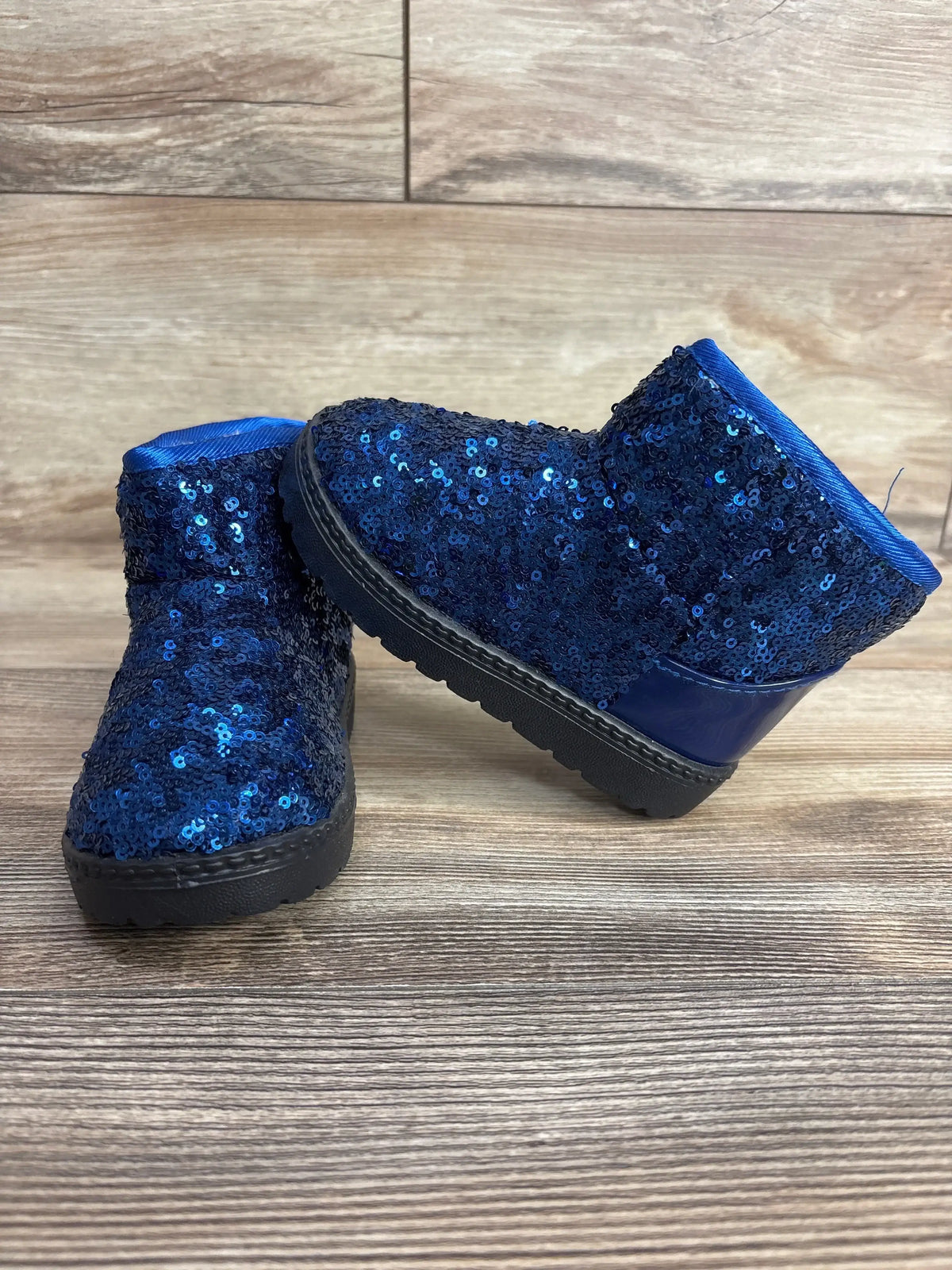 Kids blue sequin boots with black soles on wood background, children's footwear resale