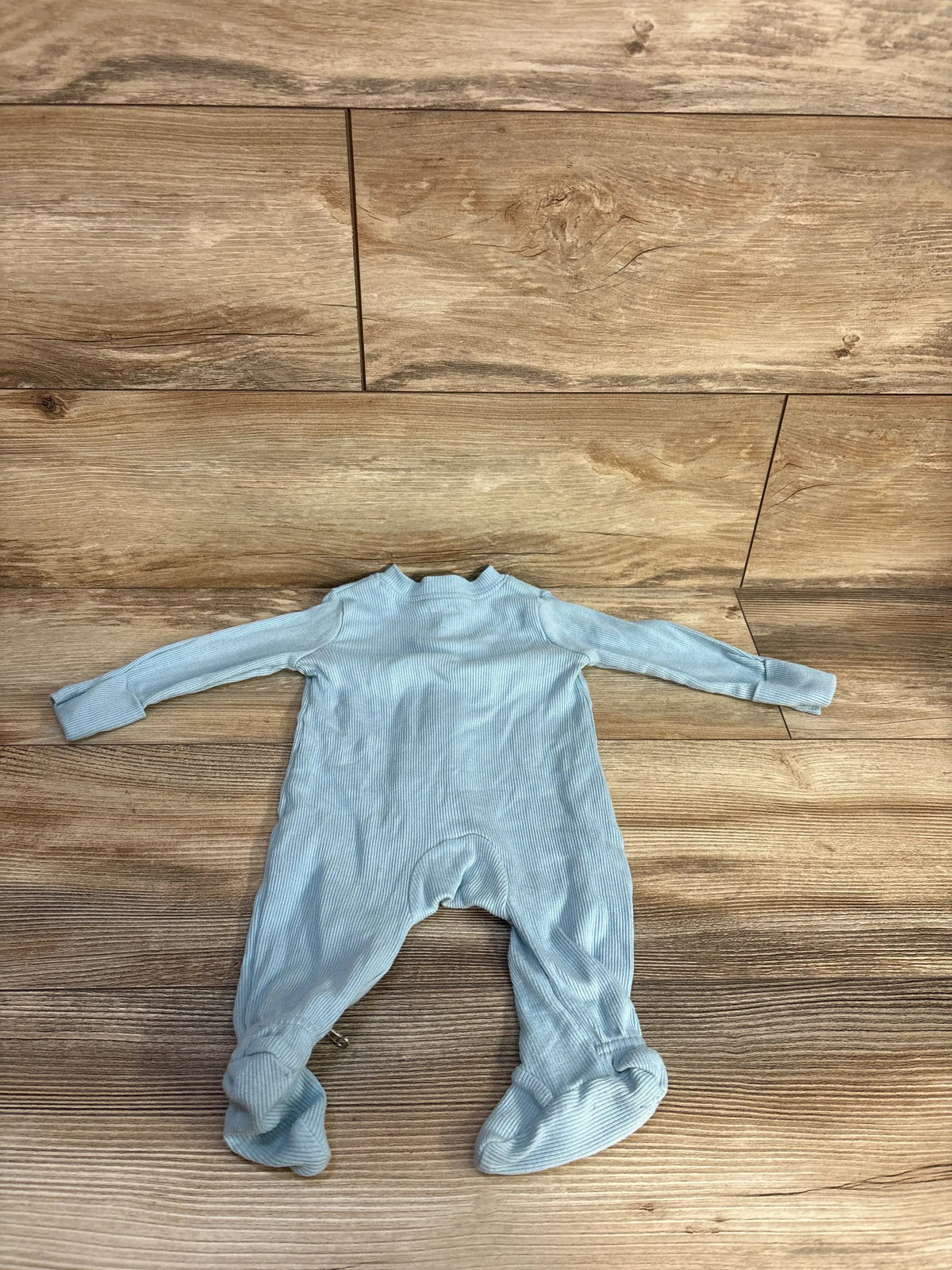 Front view of a blue Nike ribbed sleeper showcasing long sleeves and footed legs on a wood floor
