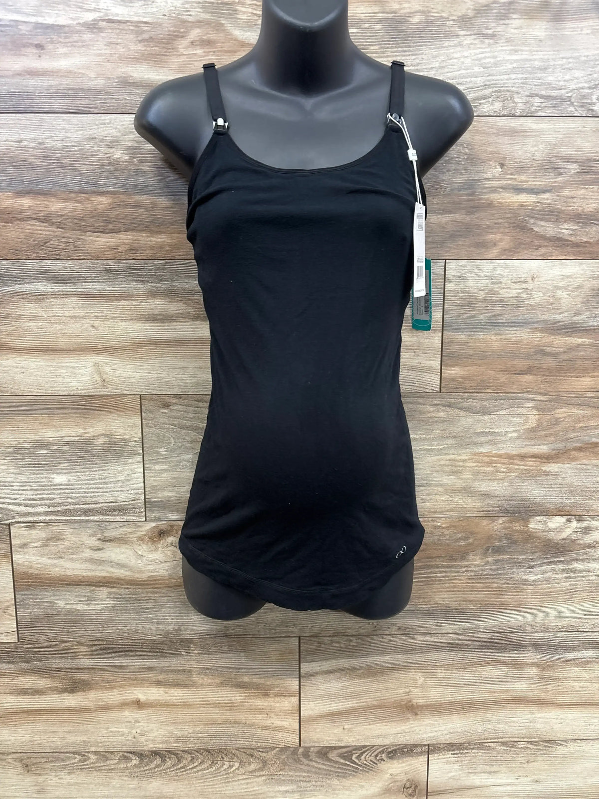 Black adjustable strap maternity tank top on black mannequin against wood background