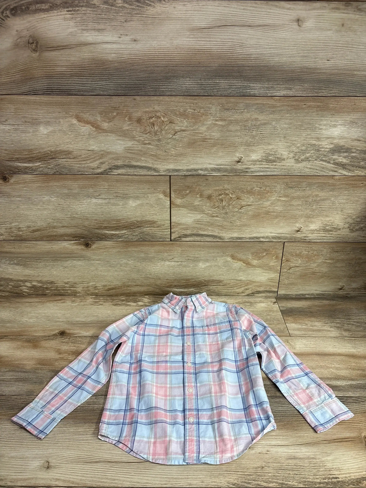 Flat lay of Janie and Jack plaid poplin button down shirt pink size 5T showcasing pink and blue plaid long sleeve collared fit on wood plank floor