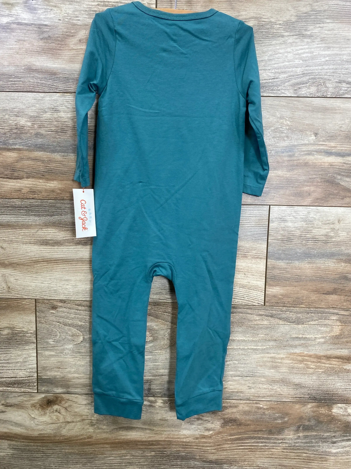 Back view of Cat & Jack teal long-sleeve 18m coverall showing attached tag and cuffed legs on wood floor background