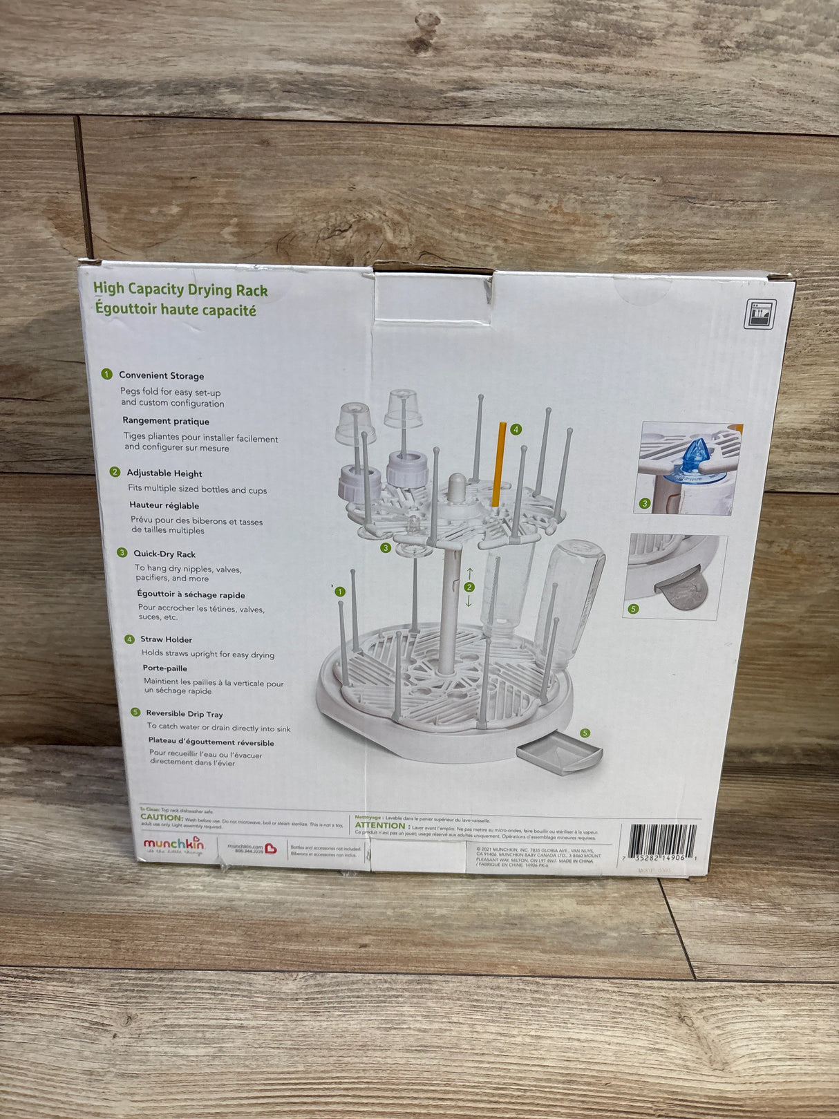 Front view of Munchkin high-capacity bottle drying rack box showing the rack with adjustable pegs and drip tray on wooden floor
