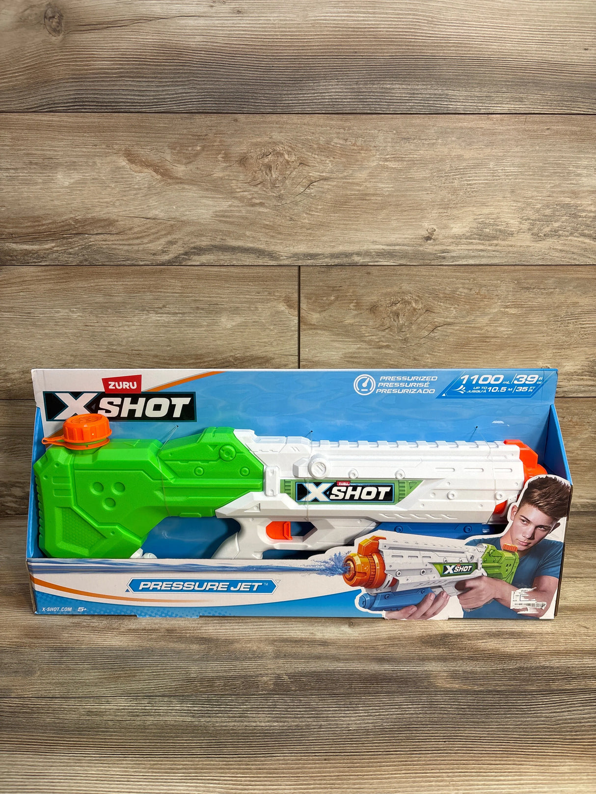 Zuru X-Shot Pressure Jet water gun toy in packaging on a wood floor