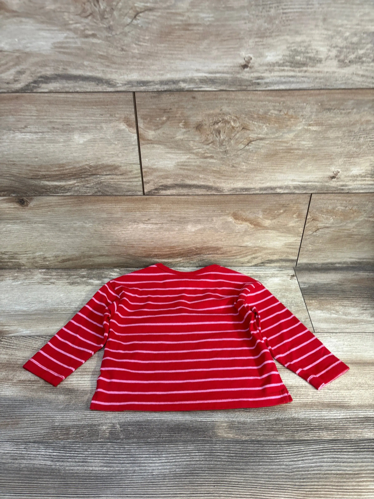 Front view of Cat & Jack red striped long sleeve shirt showcasing horizontal white stripes with wood-look floor background