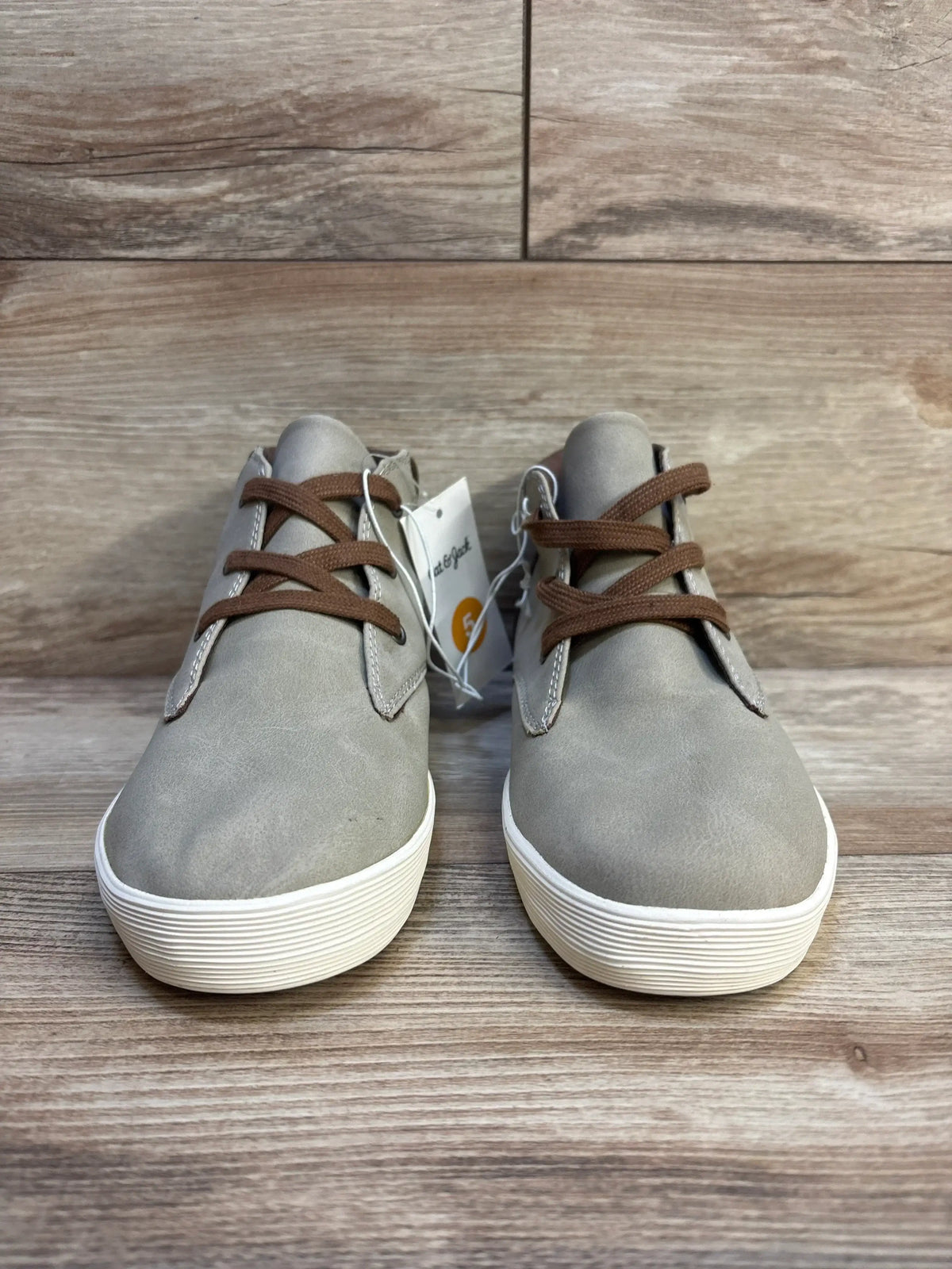 Front view of Cat & Jack Jakob gray kids’ high-top boots size 5Y showing brown laces and white ridged soles on wood floor