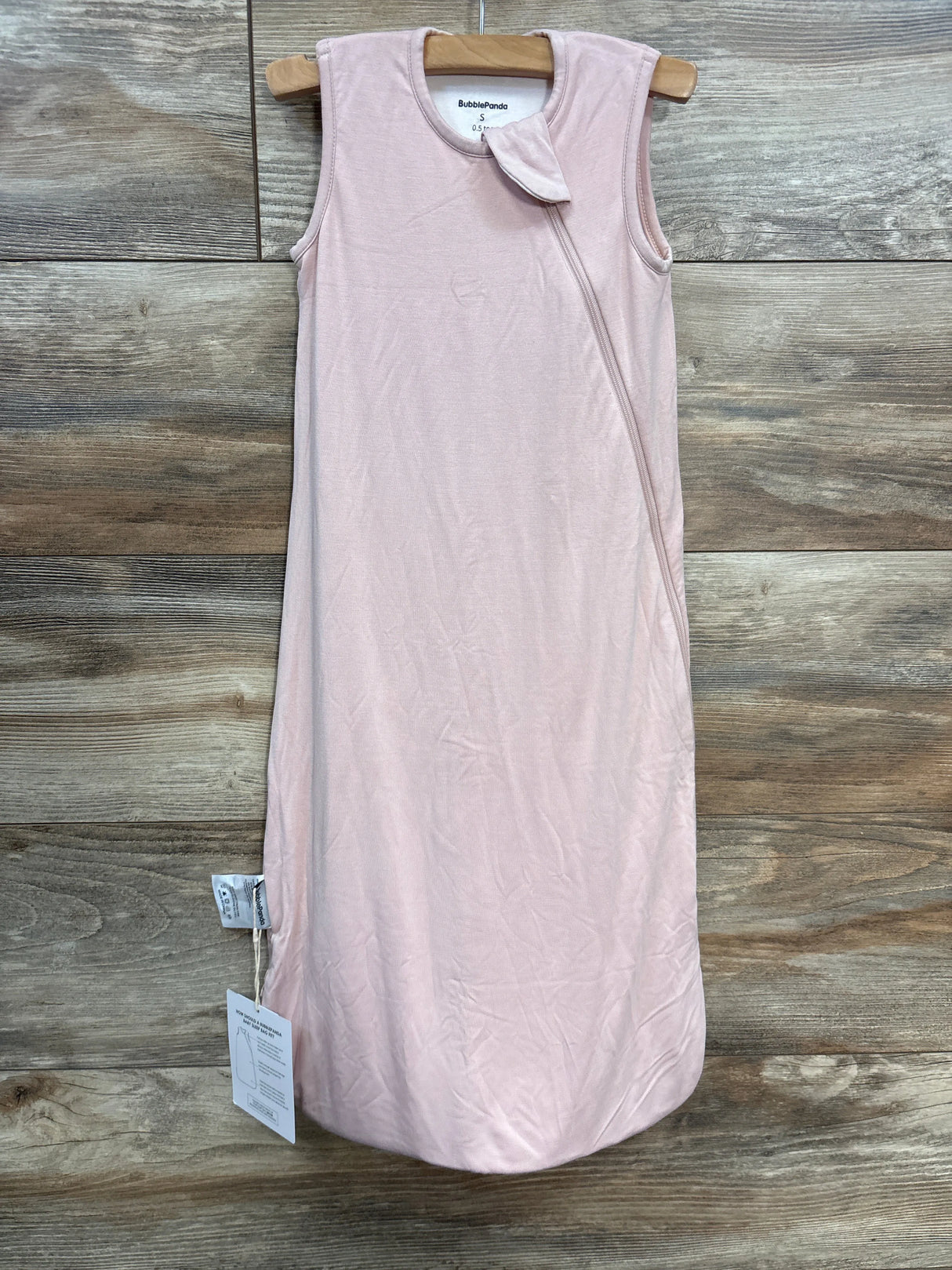 Pink sleeveless baby sleep sack by BubbaPanda on wooden background, zipper closure visible
