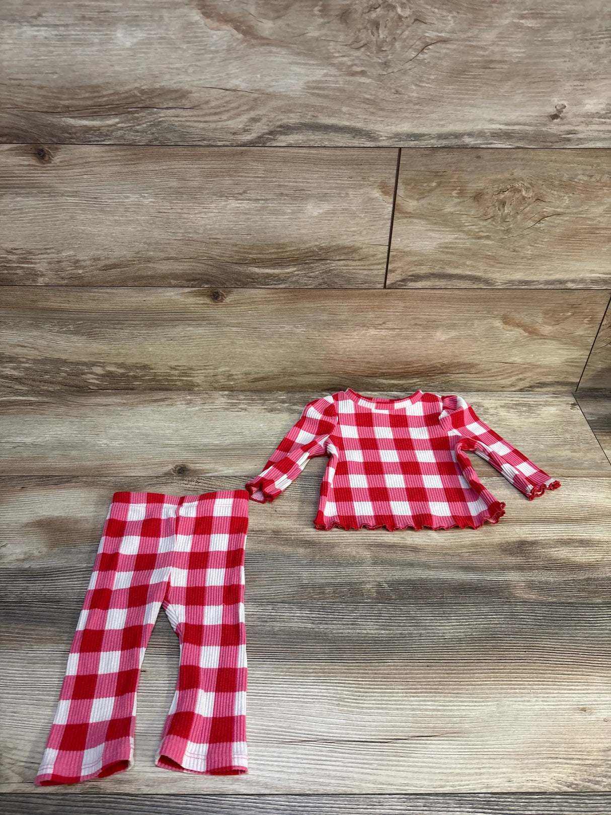 Red and white plaid ribbed kids long sleeve top and pants set on wooden background