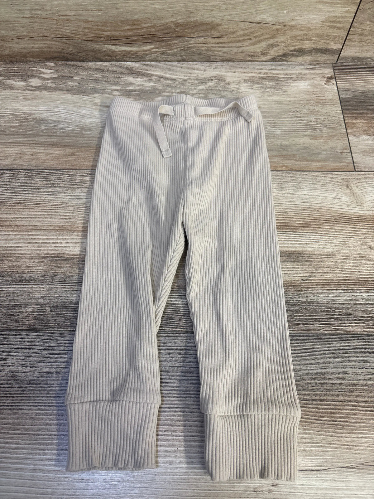 Baby Gap ribbed pants in tan for size 12-18 months on a wooden background