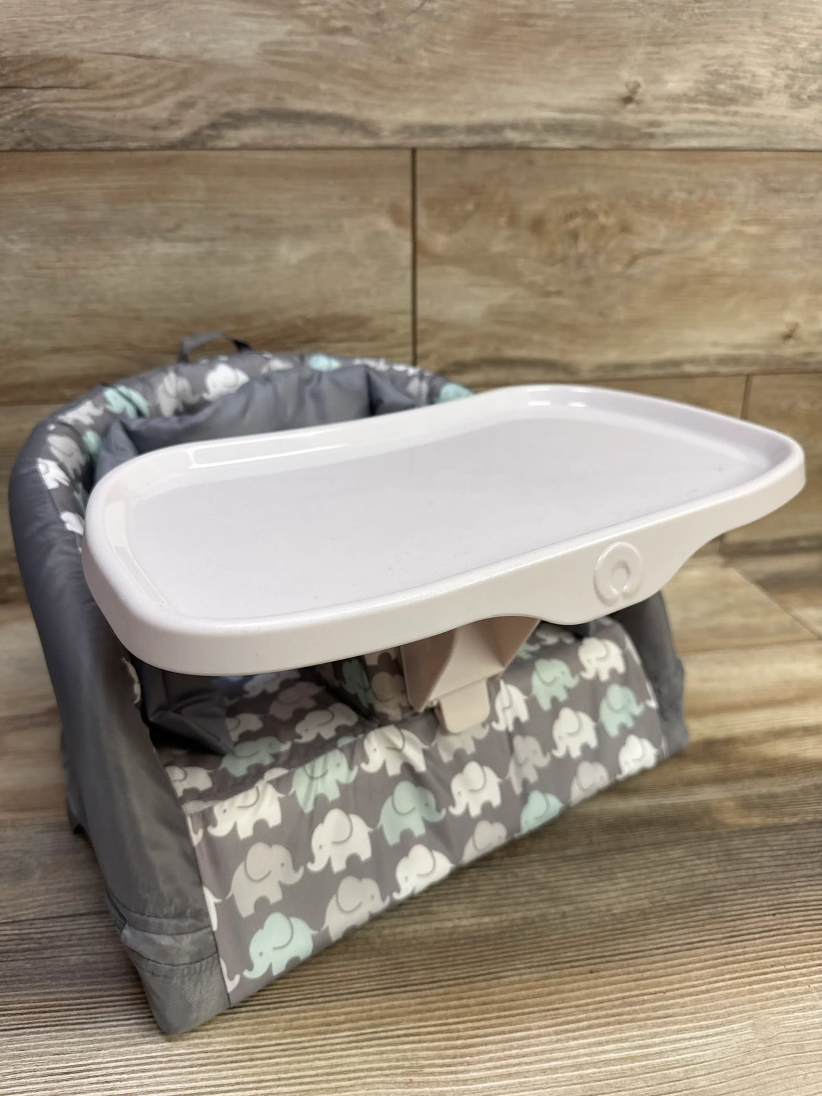 Front three-quarter view of Boppy Baby Chair showcasing gray elephant pattern and white tray with wood-panel background