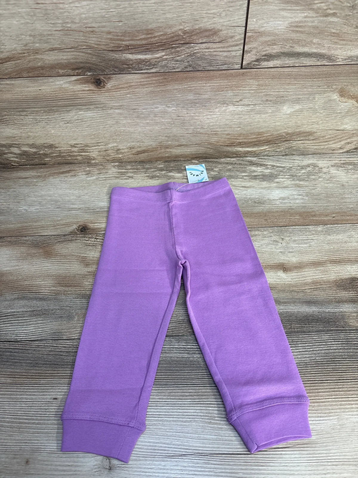 Purple baby leggings on wooden floor, soft cotton pants for infants, toddler clothing