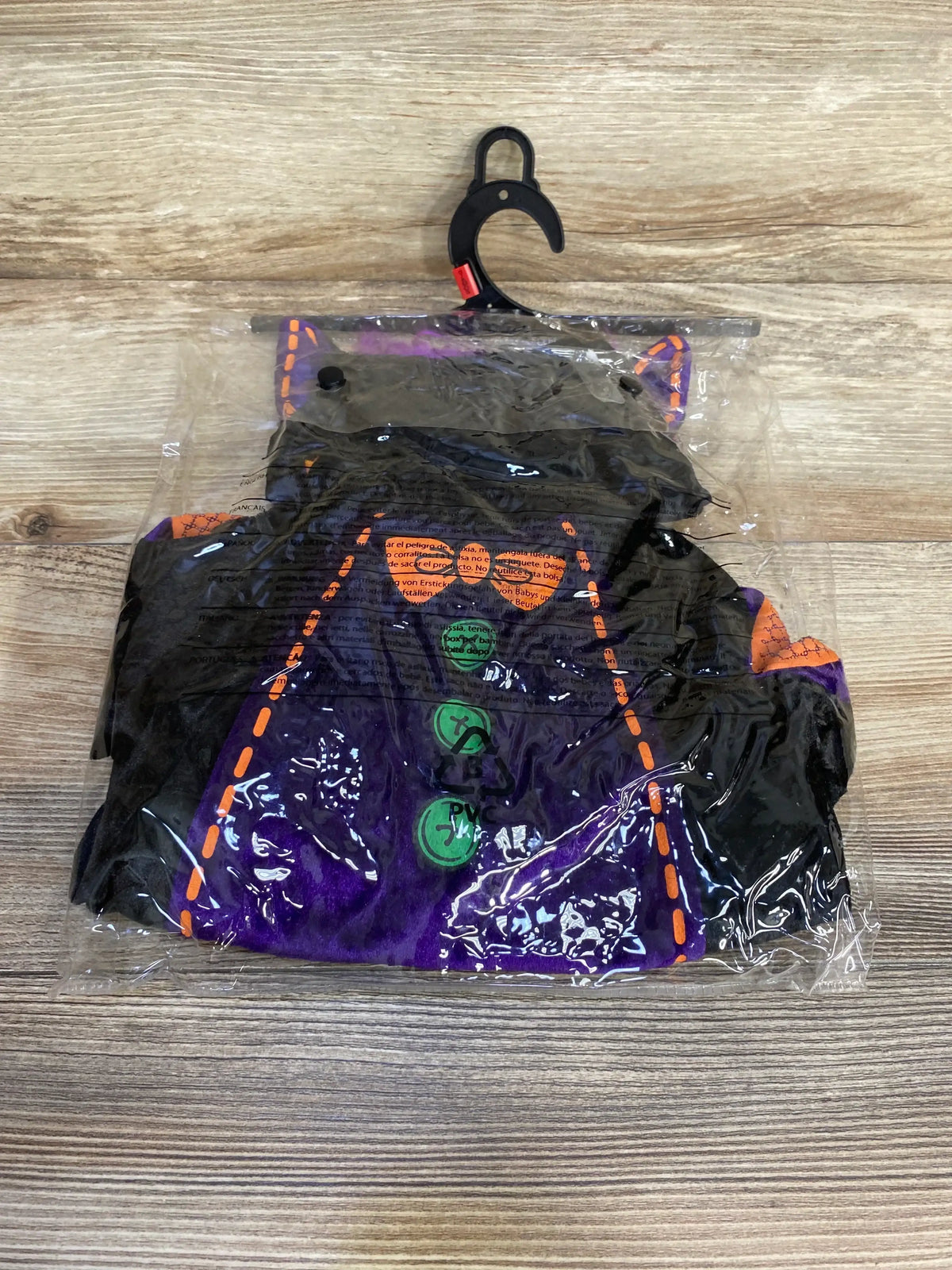 Top view of InCharacter baby bat costume in black, size 0-6 months, showcasing purple panels and orange trim in packaging